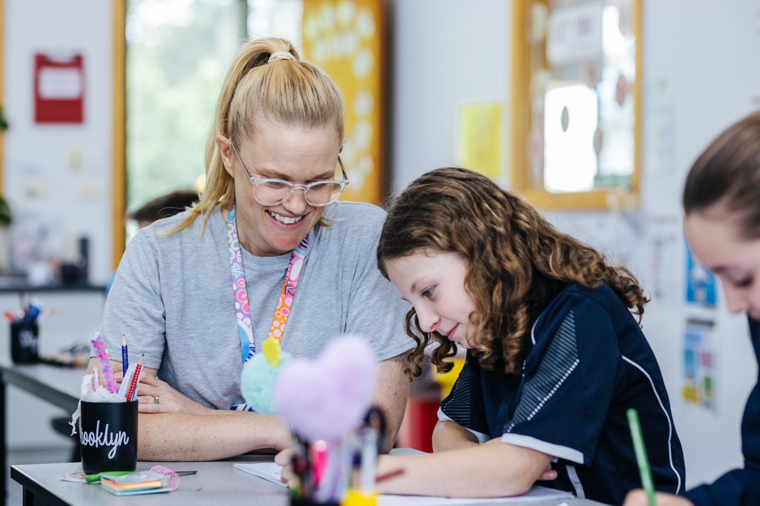 A teacher mentoring a primary student in a supportive classroom at ACC Bairnsdale in Bairnsdale VIC.