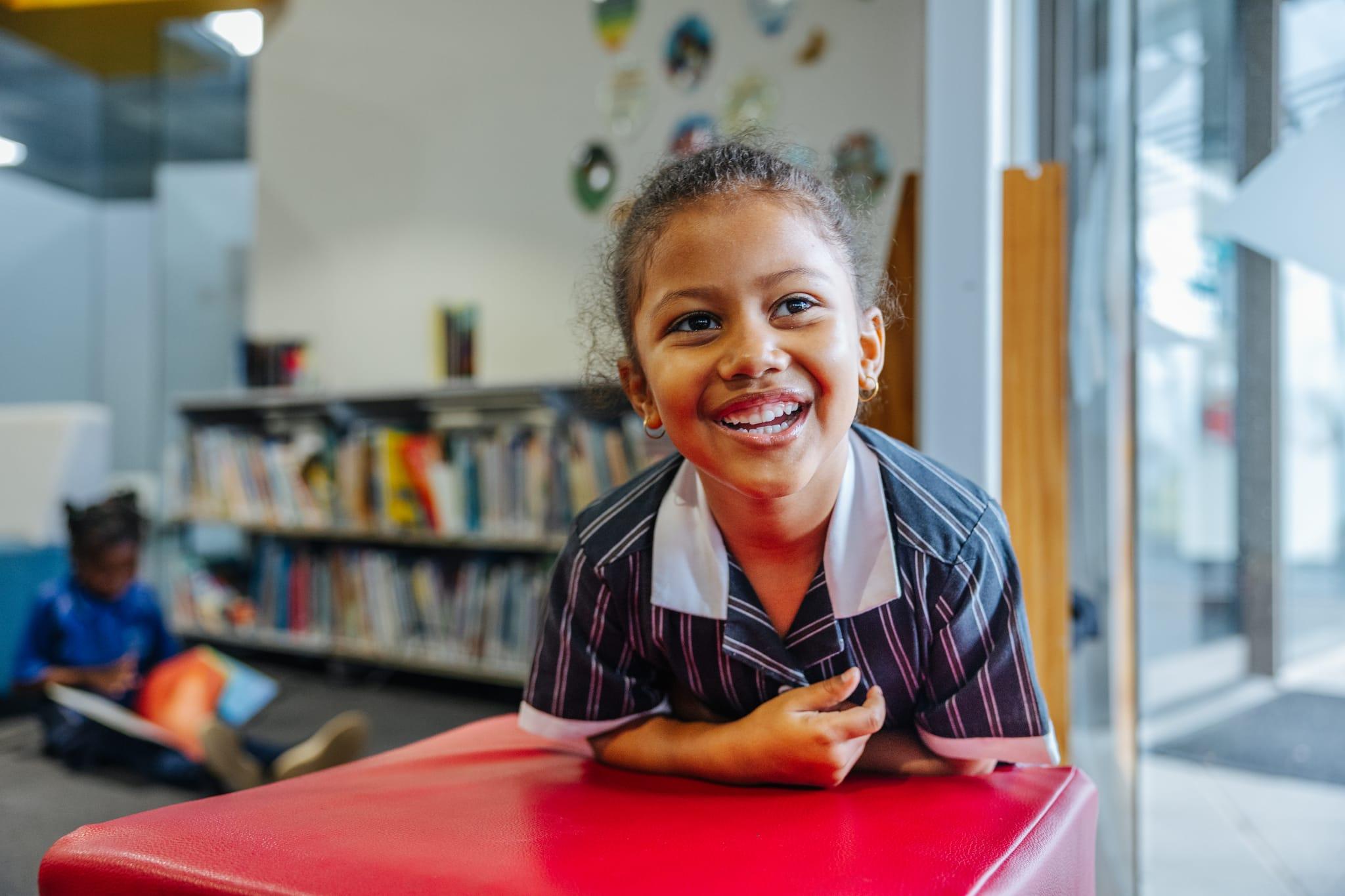 A young female student smiling in the library at Australian Christian College Benalla, an affordable Christian school in Victoria.