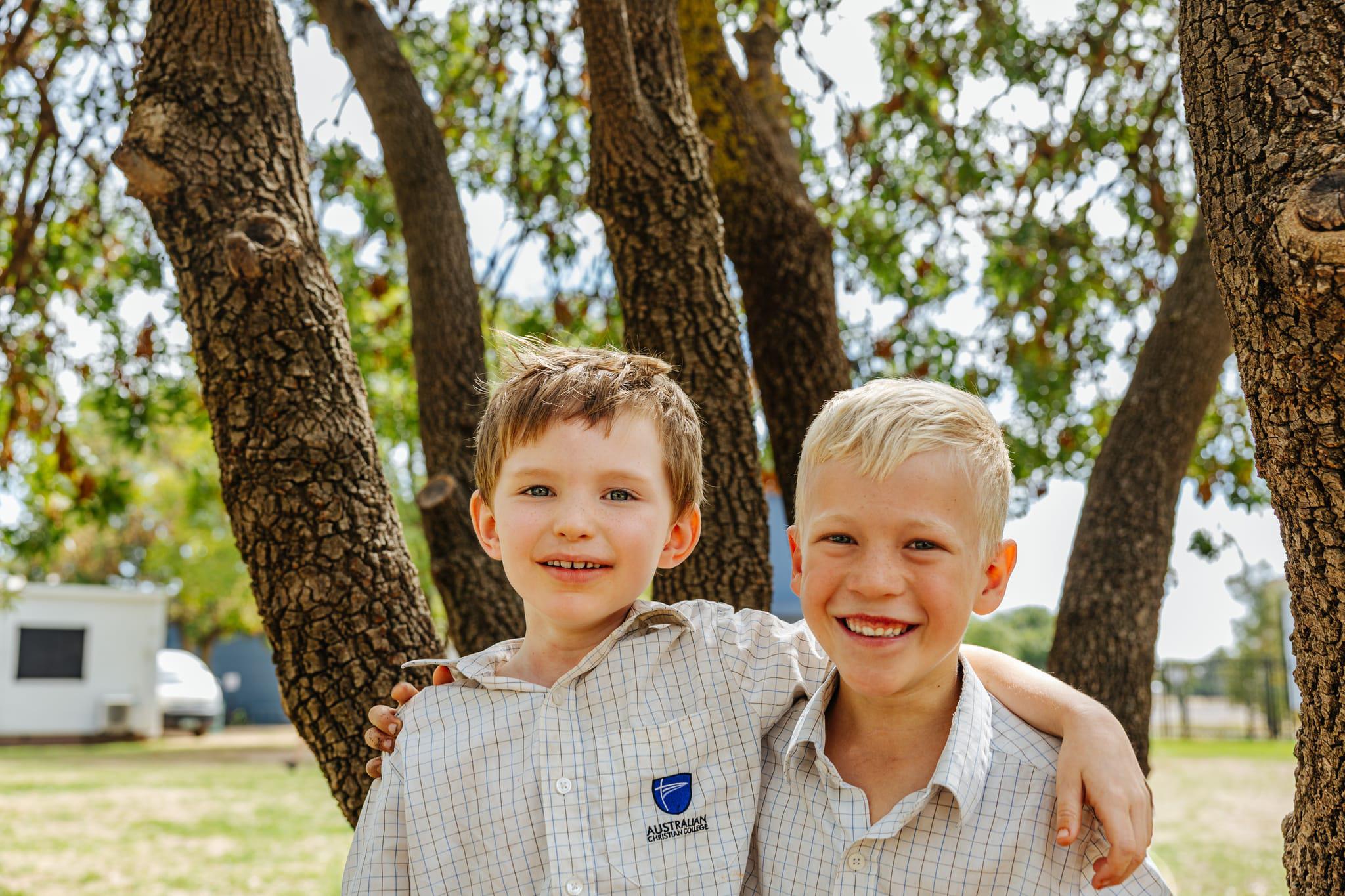 Two young male students smiling, with arms around each other, at Australian Christian College Benalla.