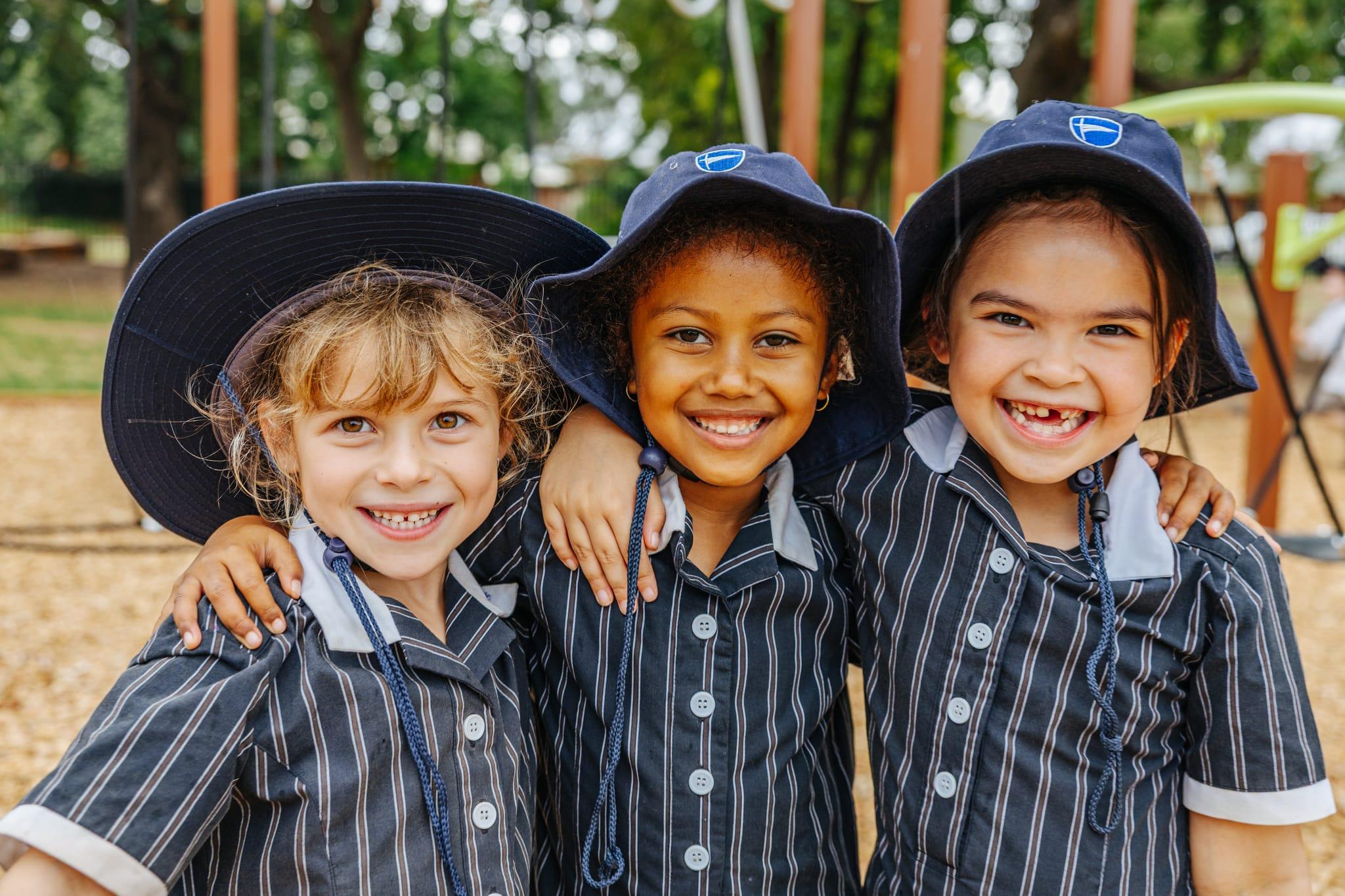 Three smiling primary school girls in their uniforms and hats at Australian Christian College Benalla, serving as the hero image for the primary showcase page.