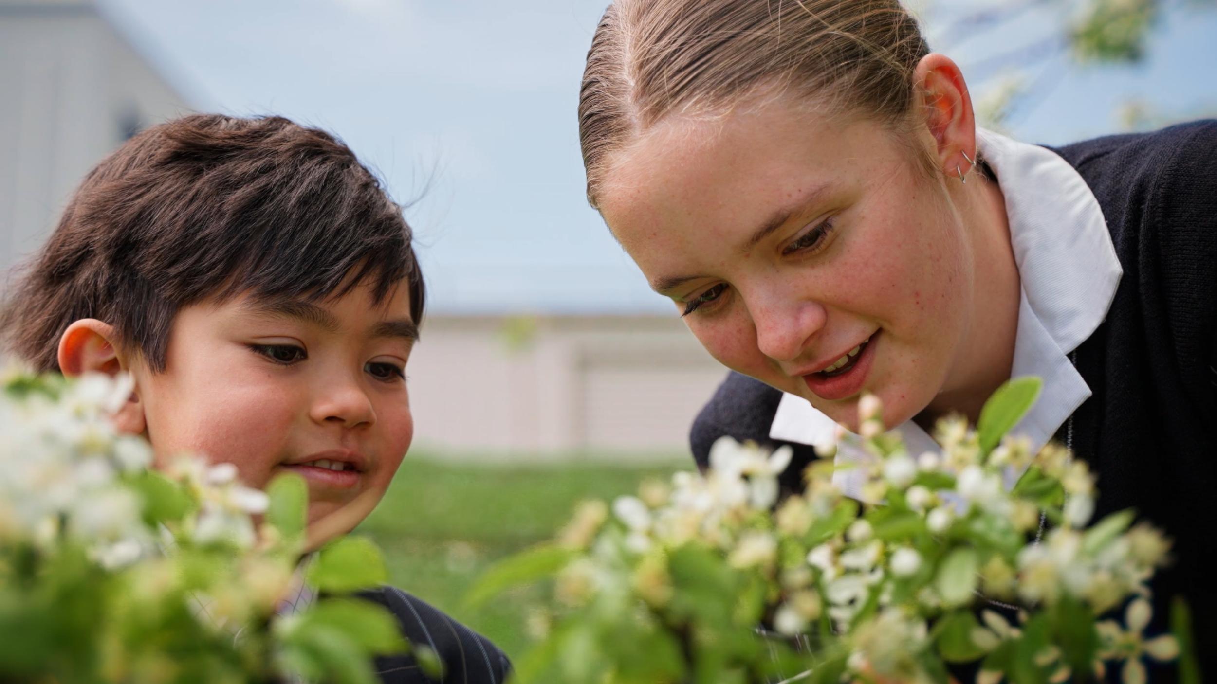 Secondary student smiling outdoors among blossoms at ACC Burnie, Somerset
