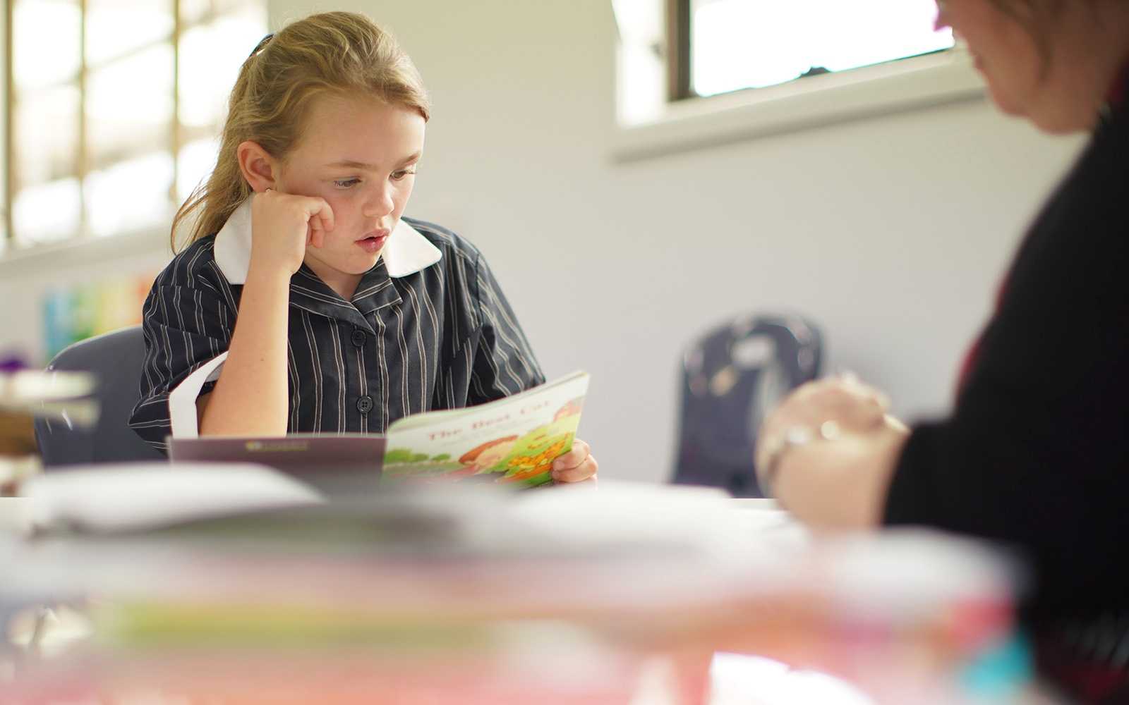 ACC Burnie female student intently reading book in classroom