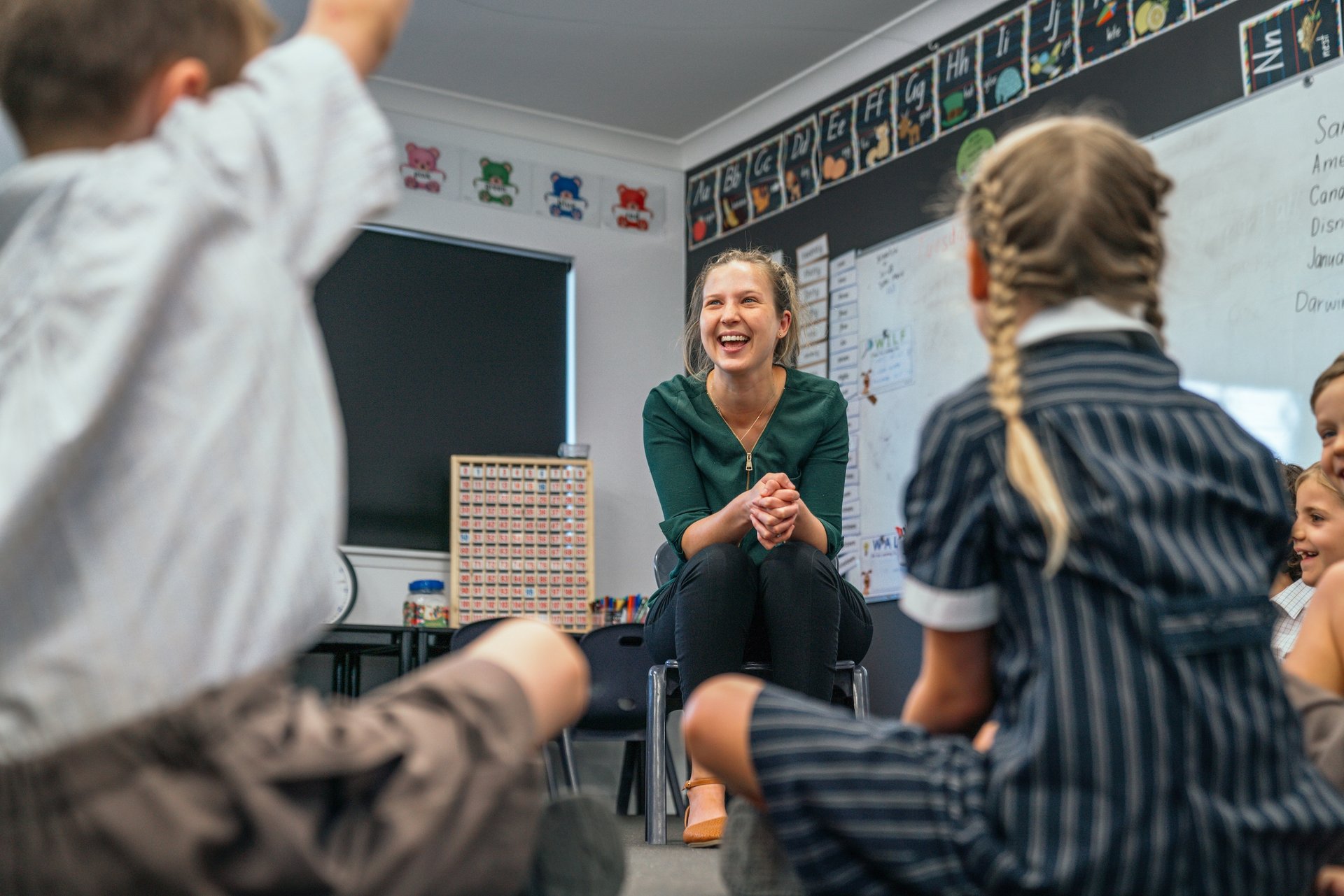 Happy primary school teacher in Australian Christian College classroom