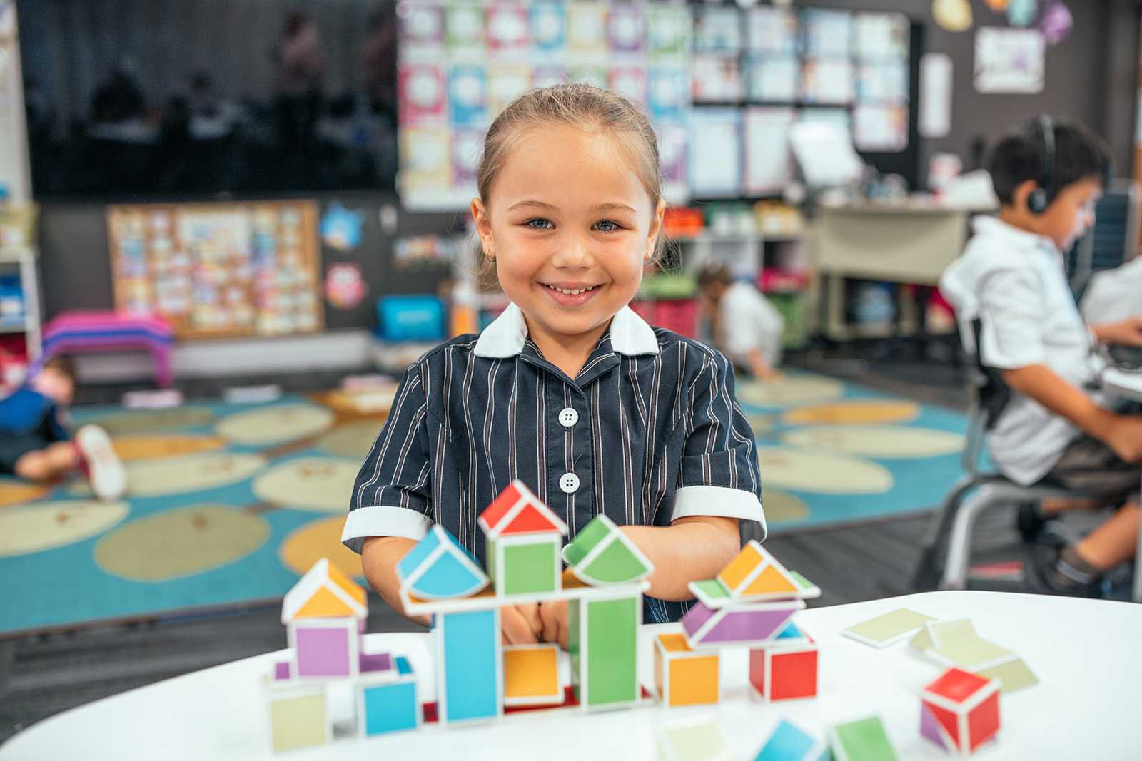 kindergarten student in Skye, Victoria smiling and playing with building blocks