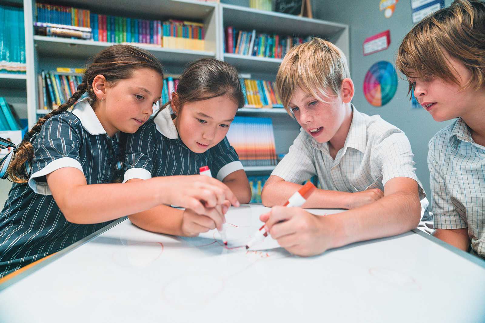 primary school students sitting and drawing together