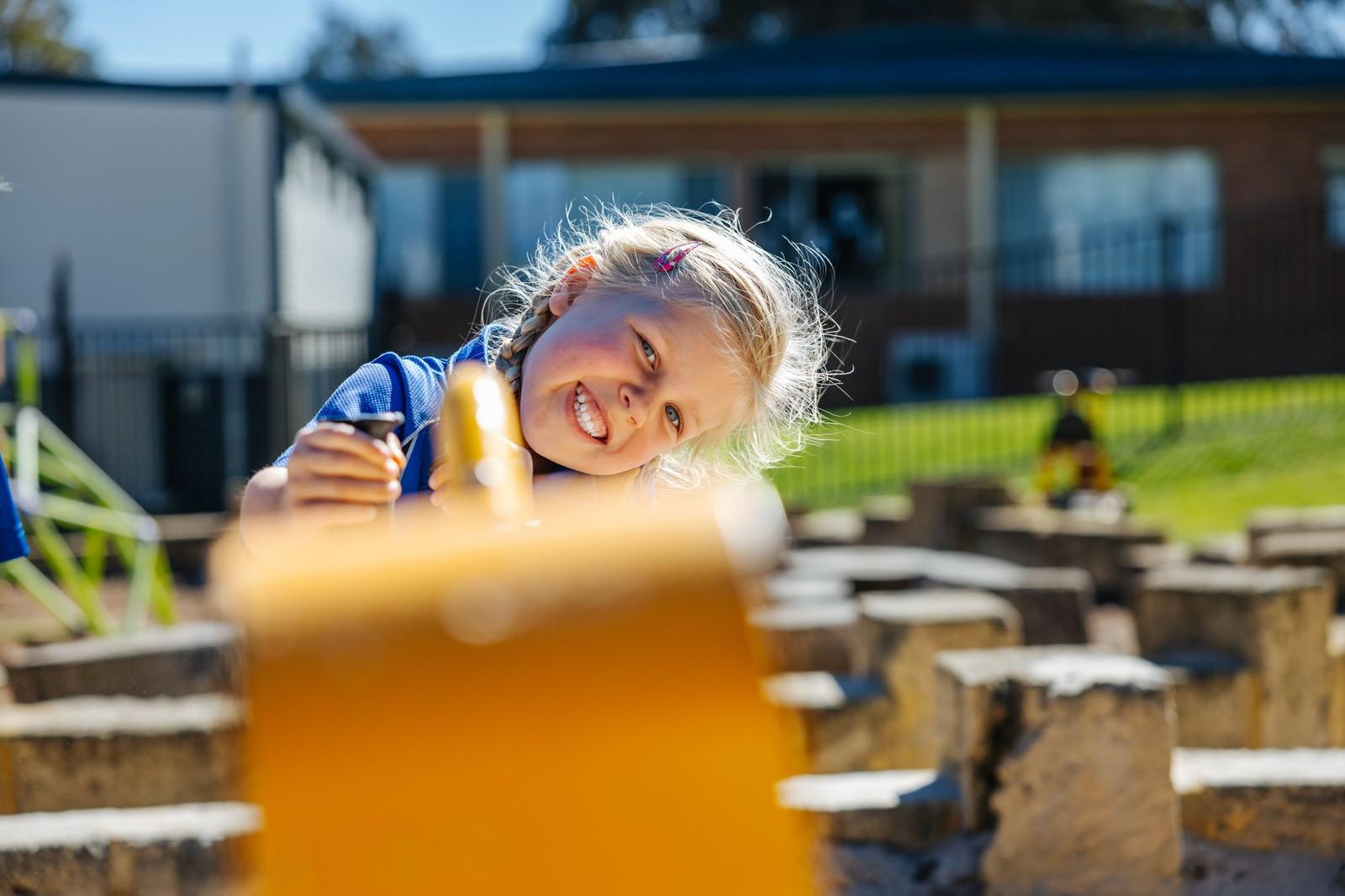 Young Kindergarten girl explores the outdoor learning area, sparking an early love of learning.