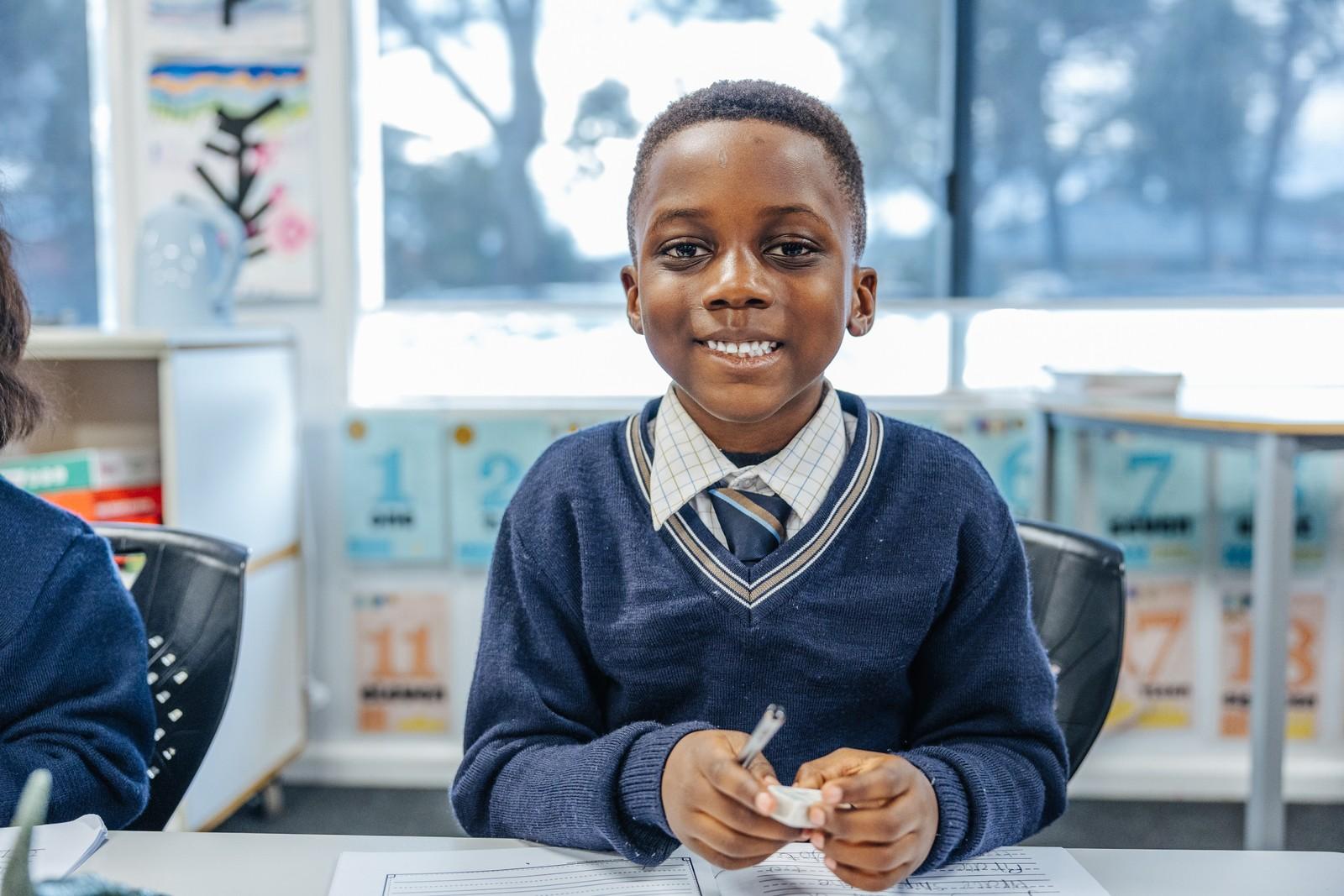 A primary student writes at his desk in a Darling Downs WA classroom, supported by small classes and personalised attention.