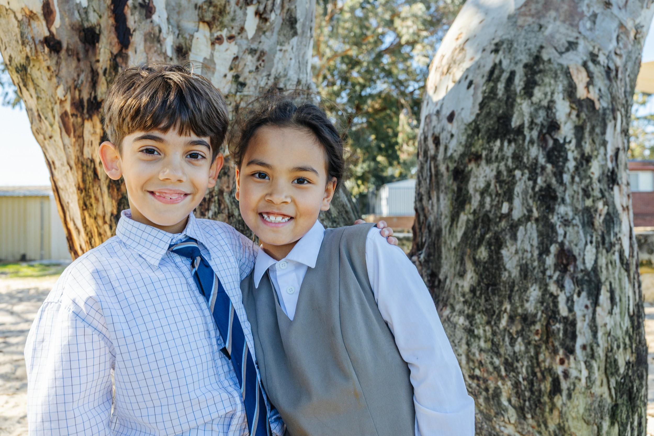 Two smiling primary students stand together outdoors at ACC Darling Downs, capturing a joyful, confident start to the early years.
