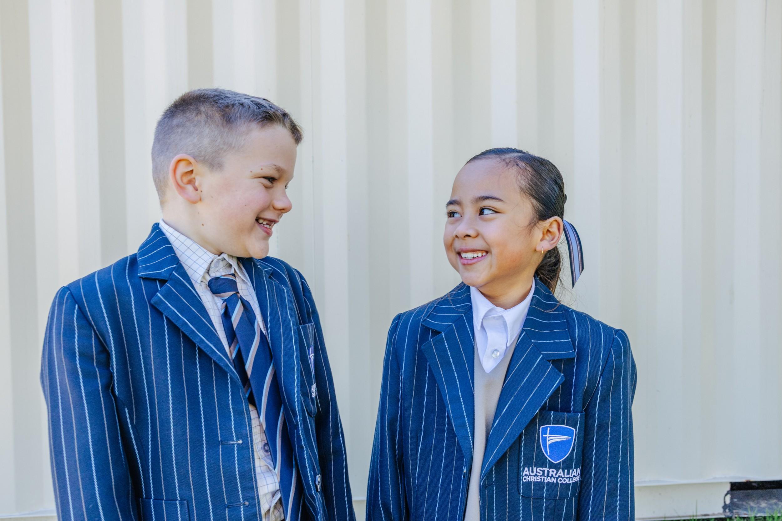 Two smiling primary students in striped blazers at ACC Darling Downs