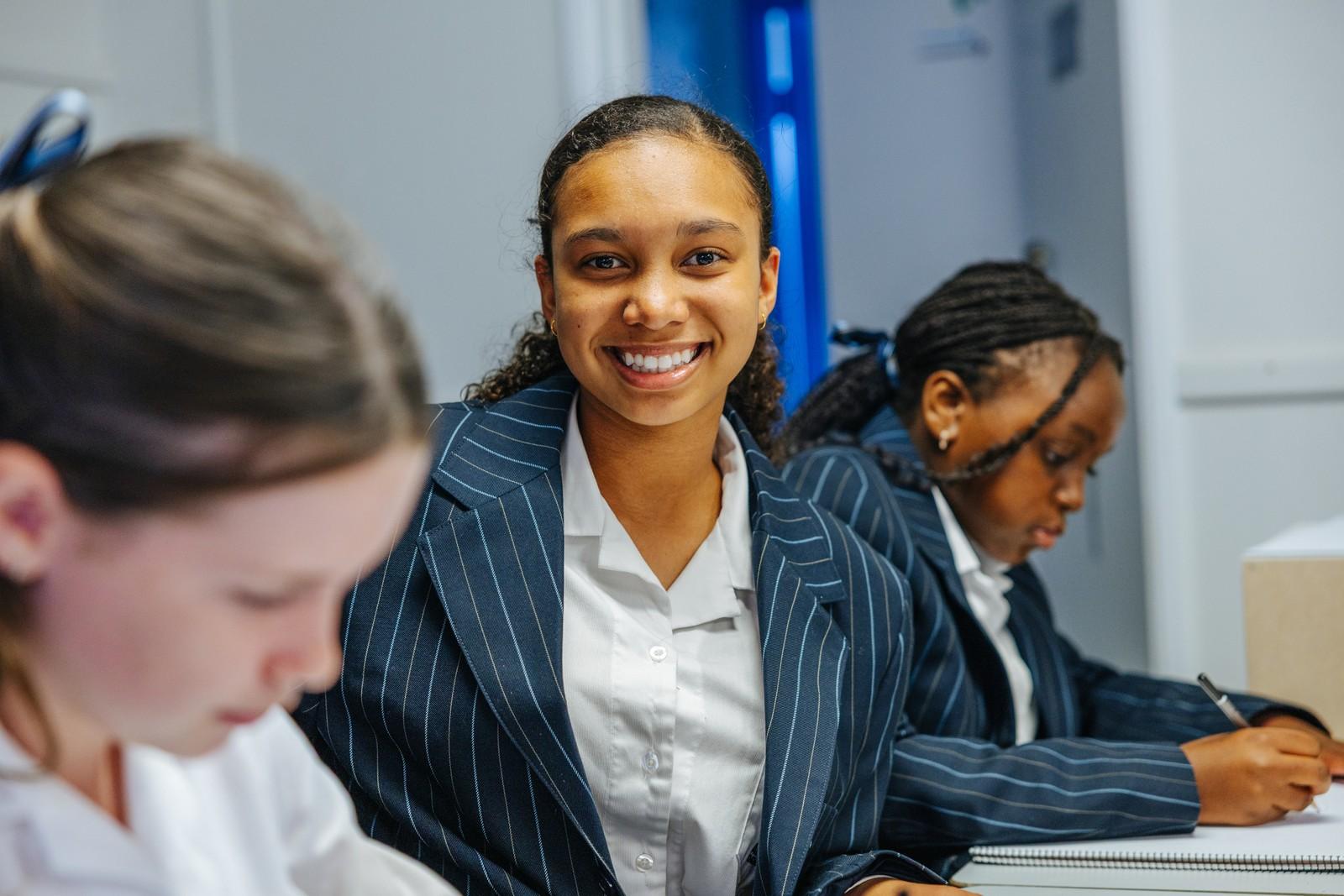 Secondary student smiling beside classmates studying in a Darling Downs classroom