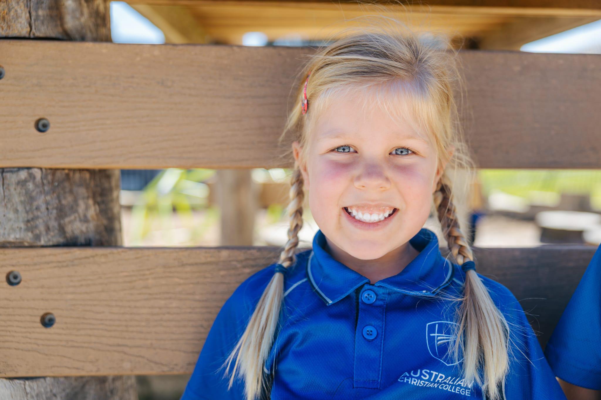 Happy student in uniform outdoors on campus, enjoying affordable Christian education at Darling Downs WA.