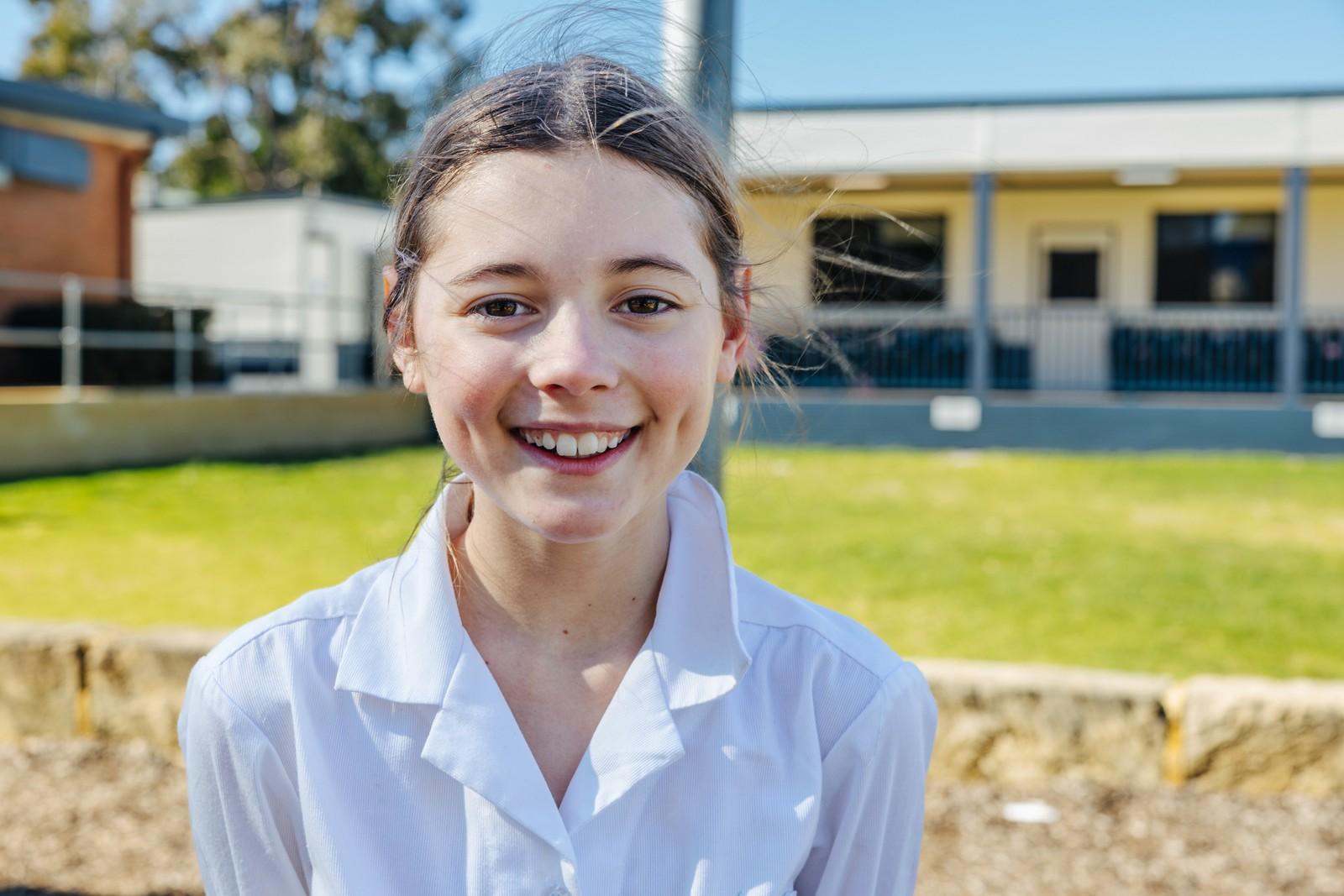 Student smiling on campus, part of the Service Learning community program at Darling Downs.