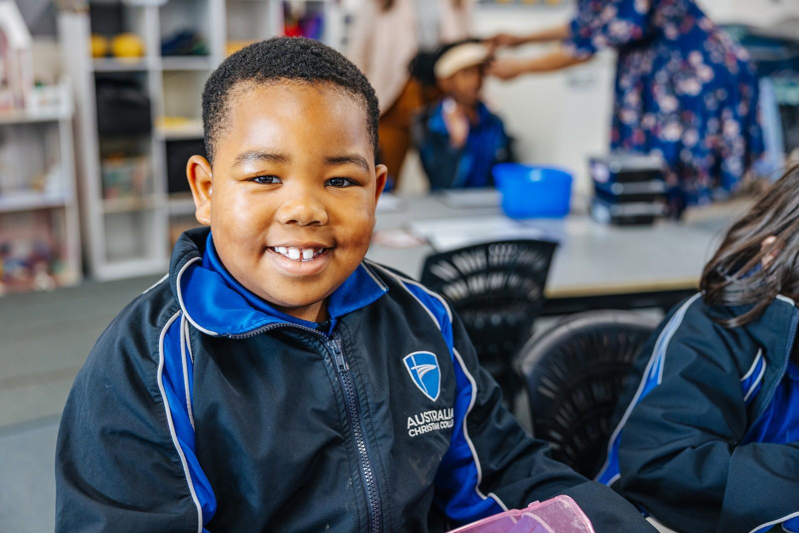 A primary student smiles in a classroom at Darling Downs WA, nurtured across learning, friendships and faith.