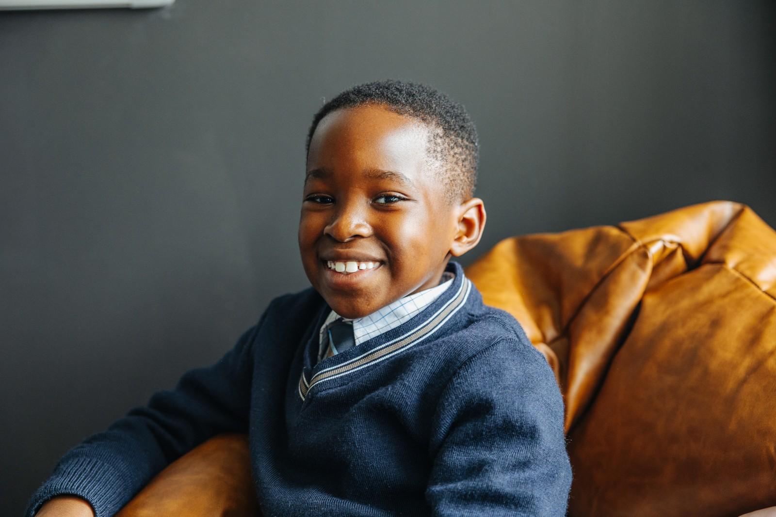 Young primary student in school uniform smiling, feeling secure and known