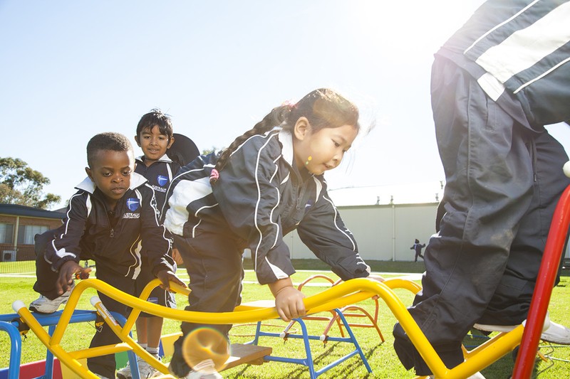 Early childhood students playing outside on play equipment