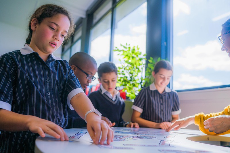 Class of secondary students working together in classroom