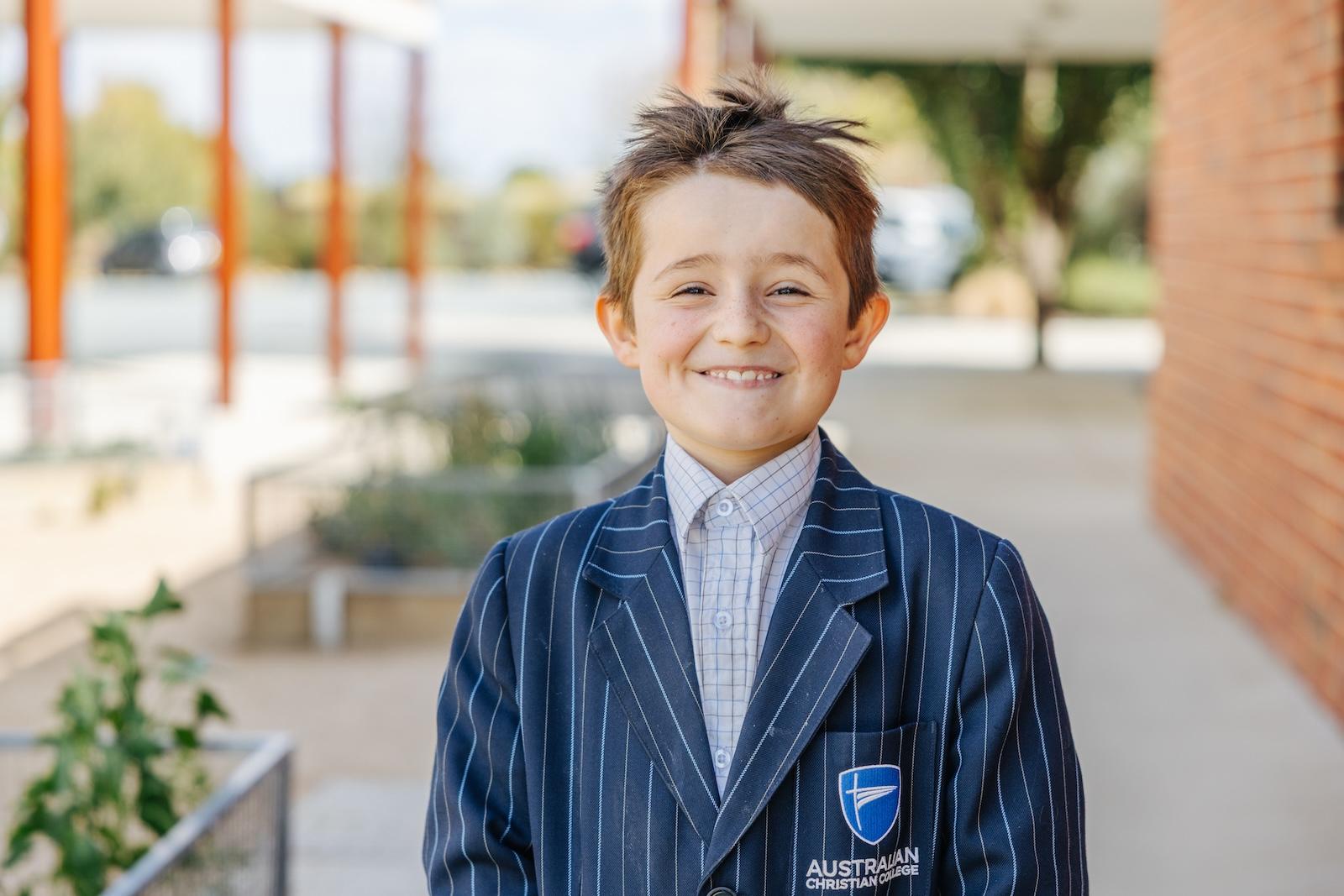 A young boy grins in his ACC Echuca uniform, embodying the confidence that grows when families can focus on learning—not worry about school fees.