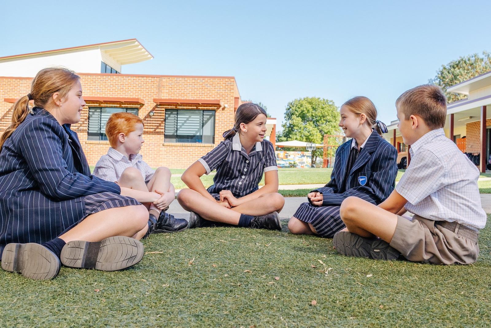 Students gathered on the school lawn mid-conversation. Giving off vibes of the friendly, inclusive feel that defines the enrolment experience at ACC Echuca.