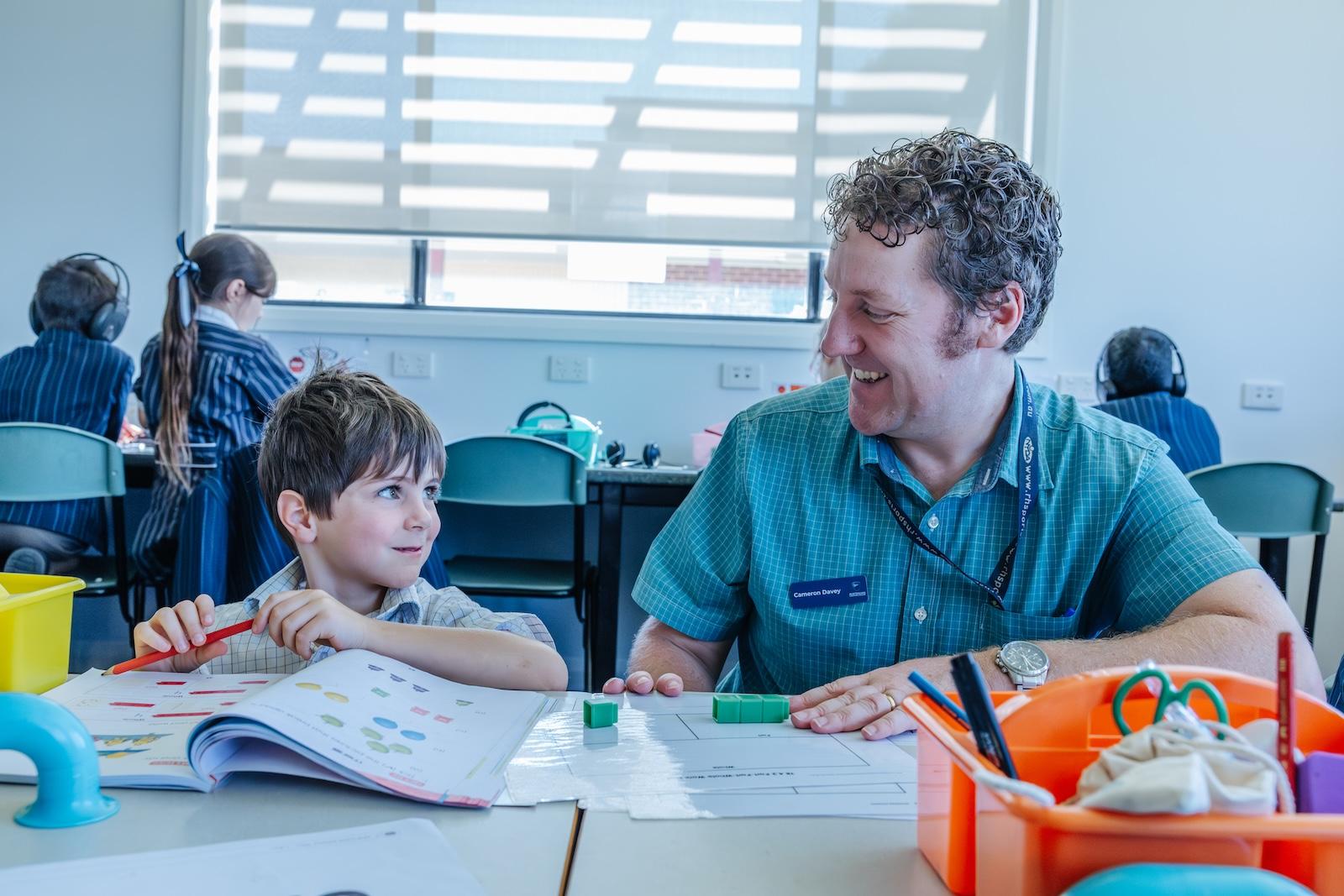 A primary teacher works one-on-one with a young student using hands-on maths materials, laying the groundwork for confidence and curiosity at ACC Echuca.
