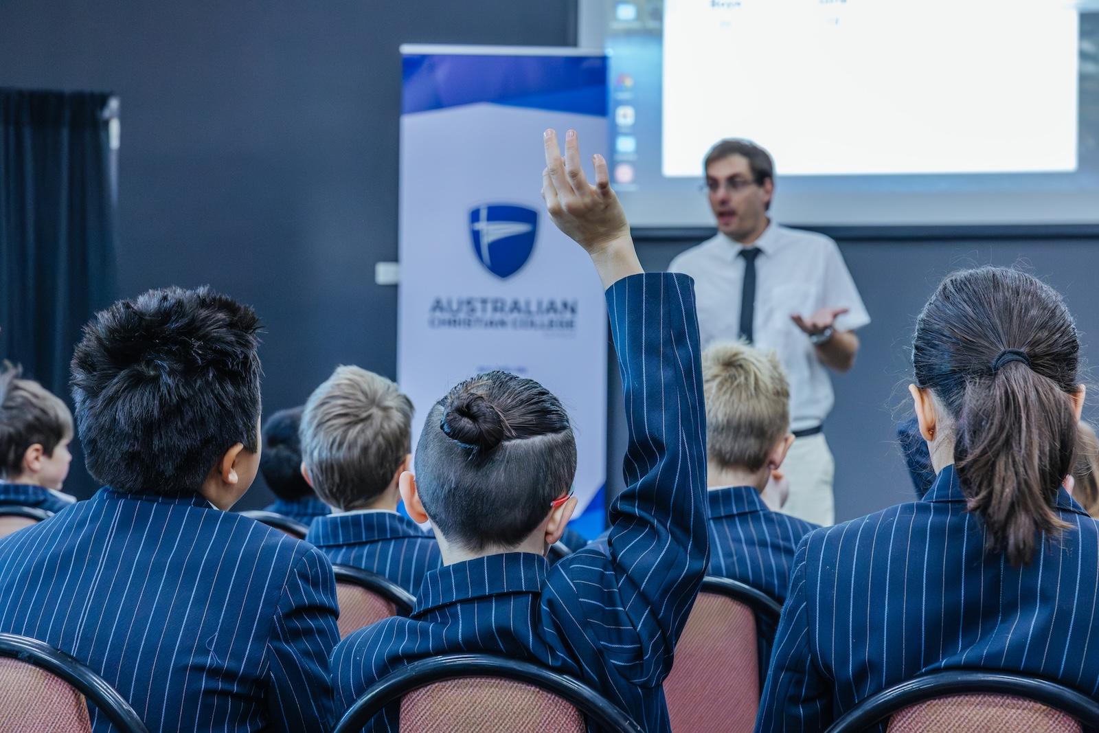 Student raising hand during a presentation at ACC Echuca, symbolising active learning and purposeful Christian education.