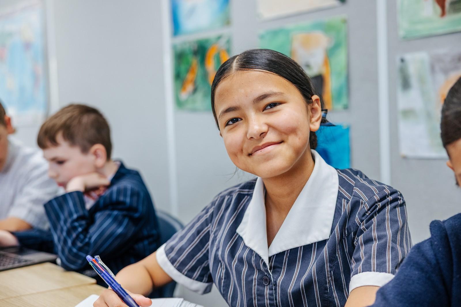 Student smiling in a classroom during a Christian education lesson