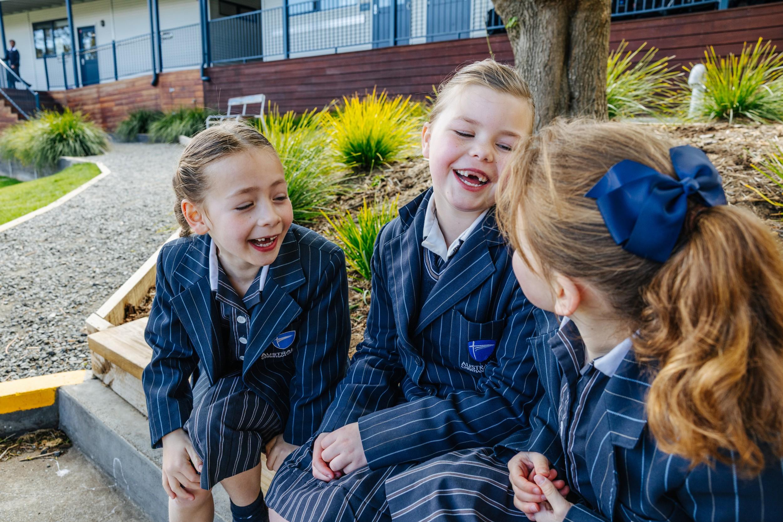 Primary students laughing together on campus at ACC Hobart