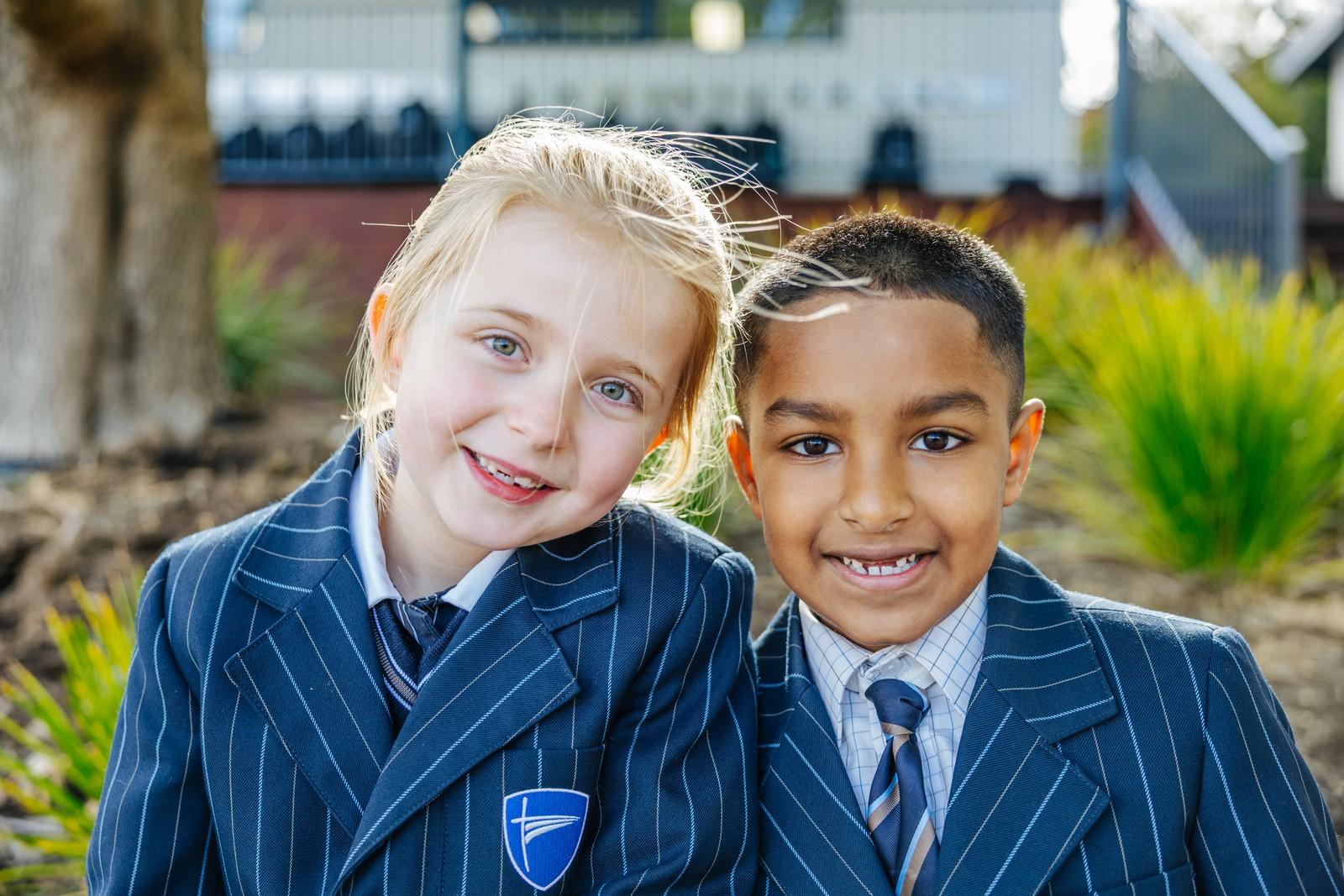 Two primary students smiling together on the Geilston Bay campus