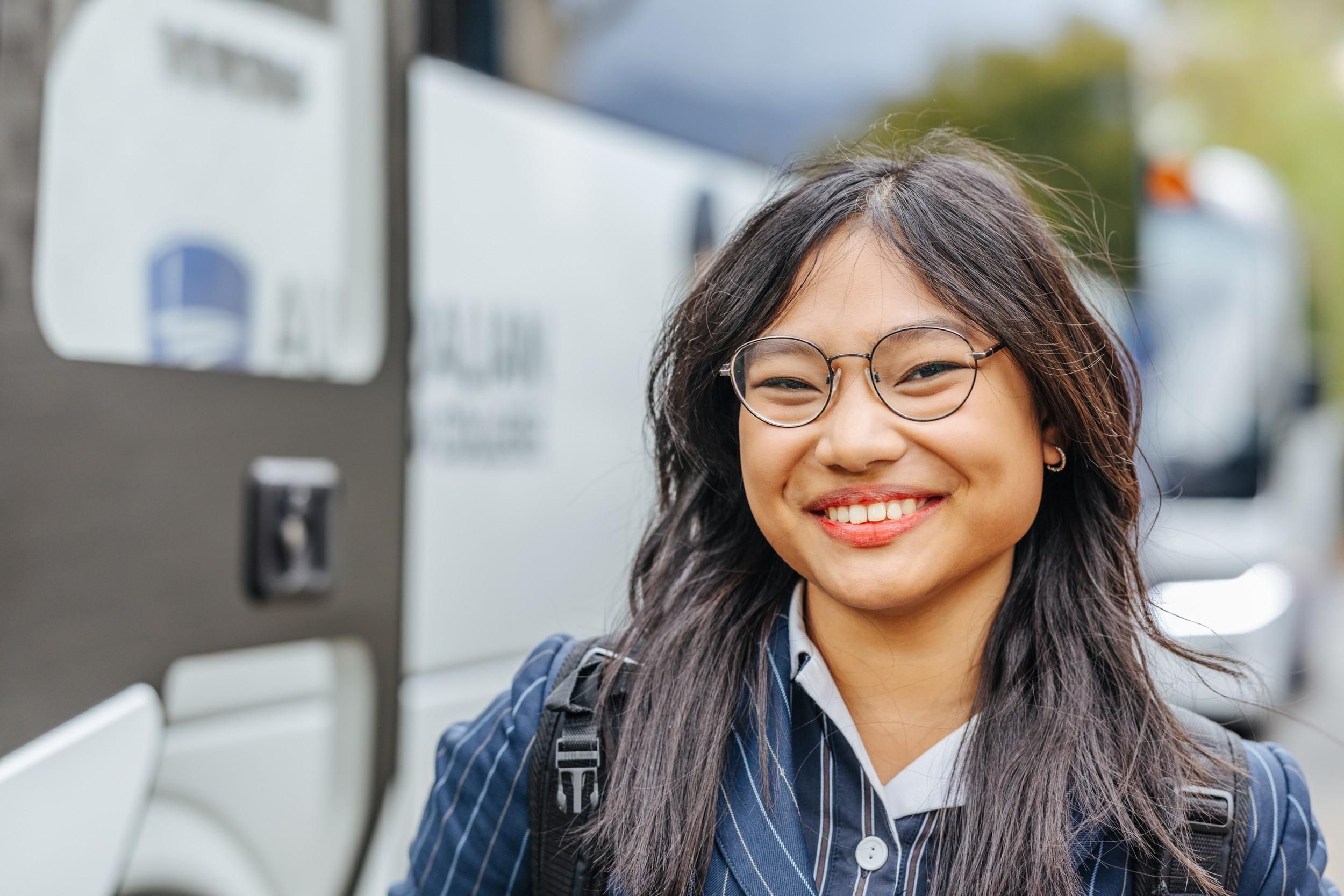 A smiling ACC Hobart student steps off the bus, ready for the school day.