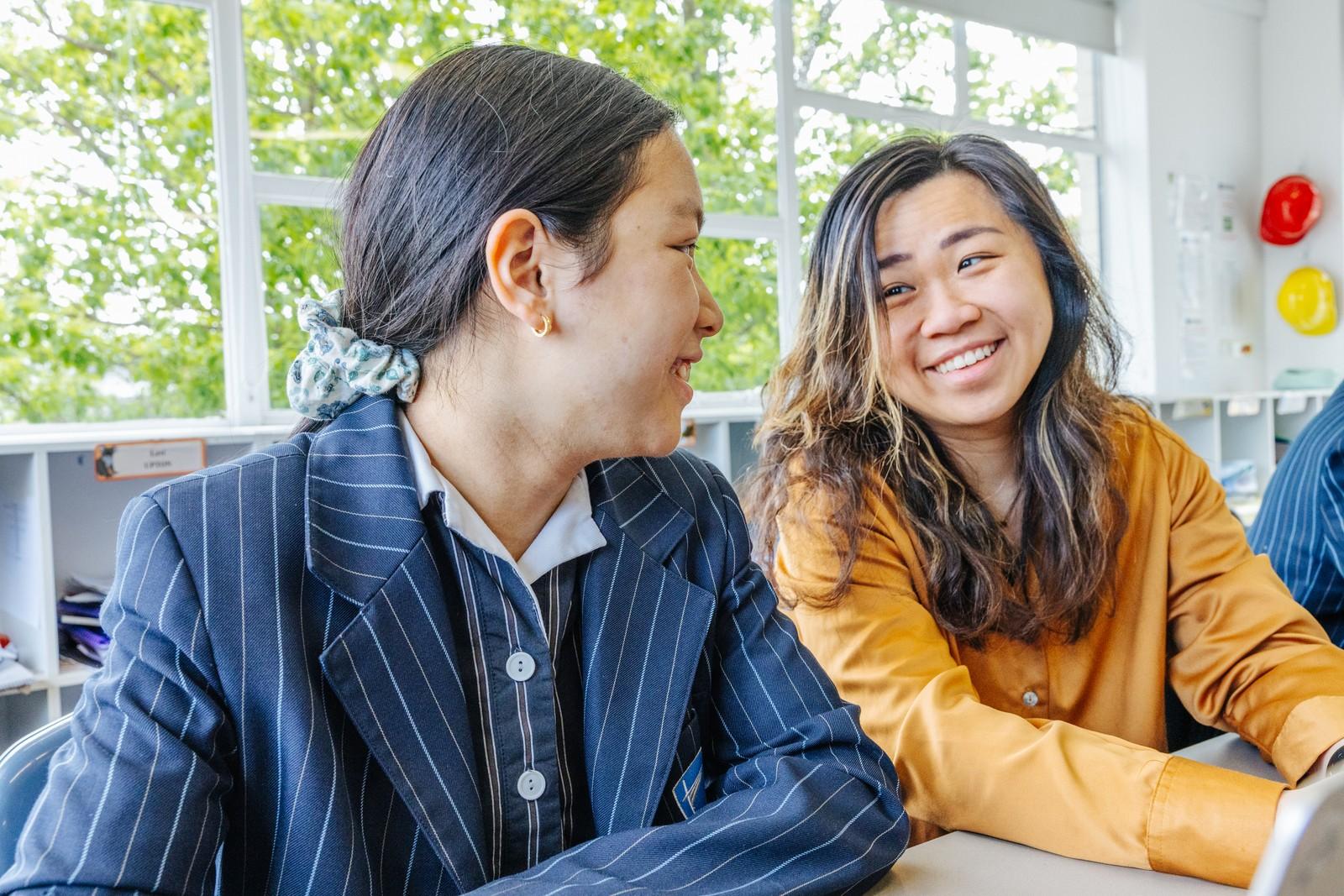 Two secondary students in Geilston Bay share a smile during a classroom discussion
