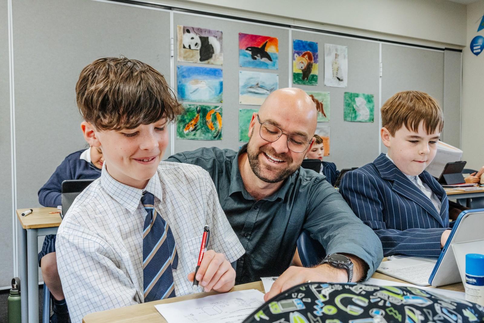 A teacher supporting a secondary student during class at Geilston Bay