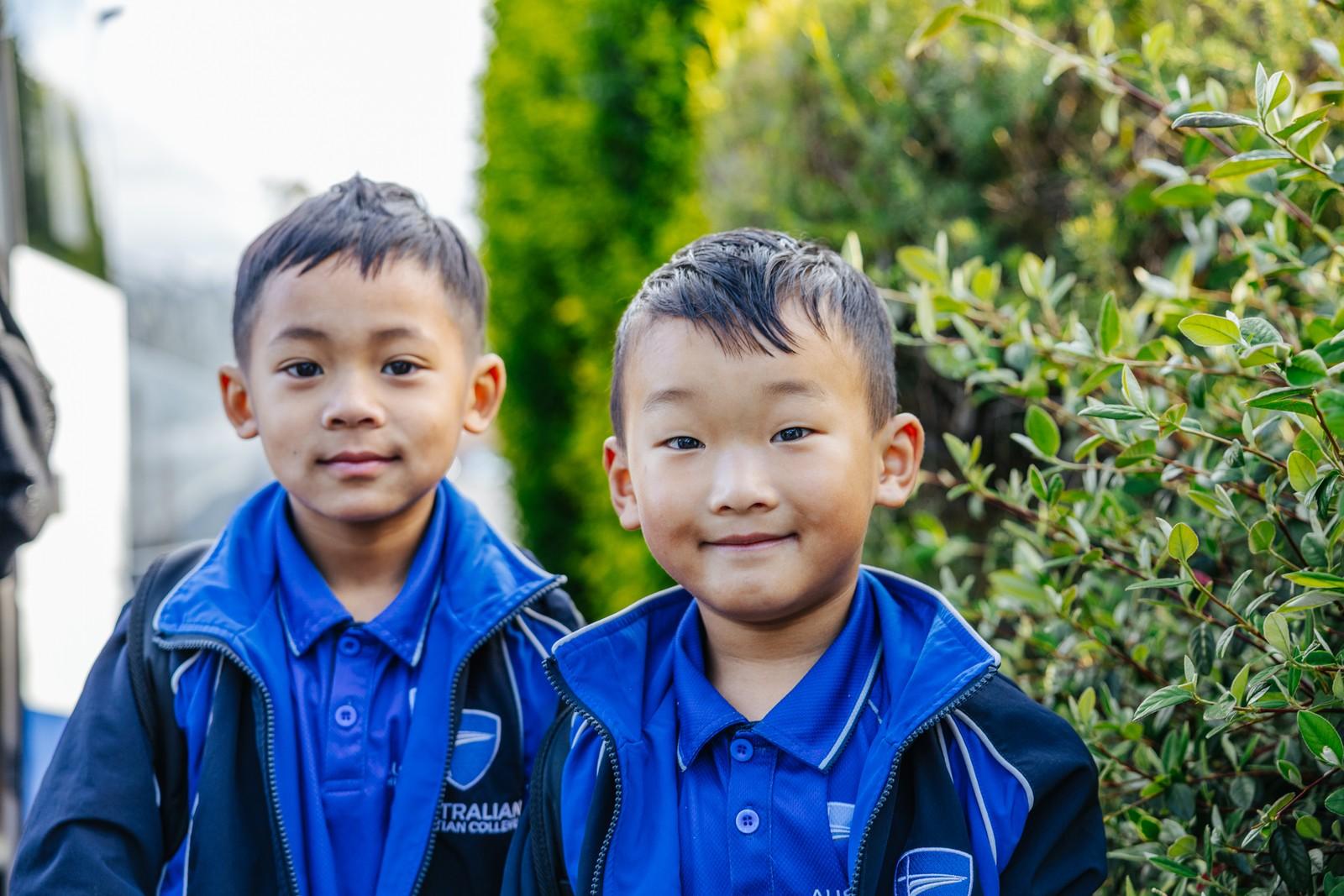 Two Primary students in school jumpers smiling outside in Hobart TAS.