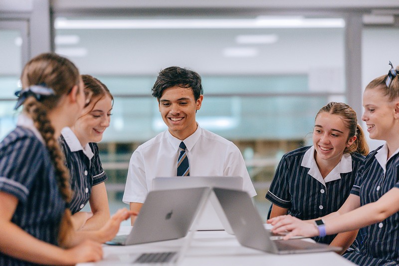 High school student smiling writing on whiteboard