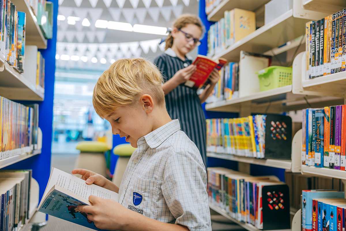 Primary school students reading books in the library