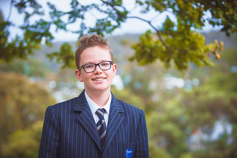 ACC Hobart Secondary student standing outside wearing uniform blazer