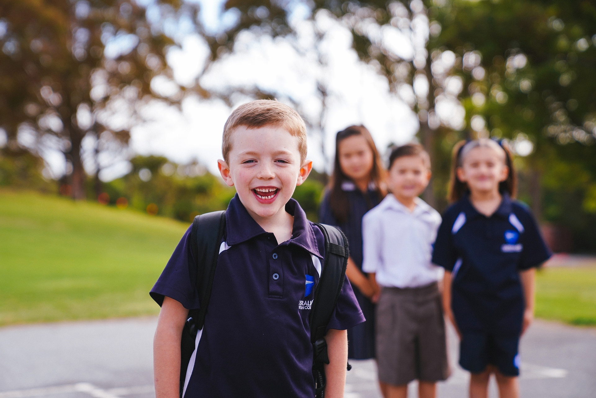 ACC Hume primary boy wearing sports uniform and backpack on school oval