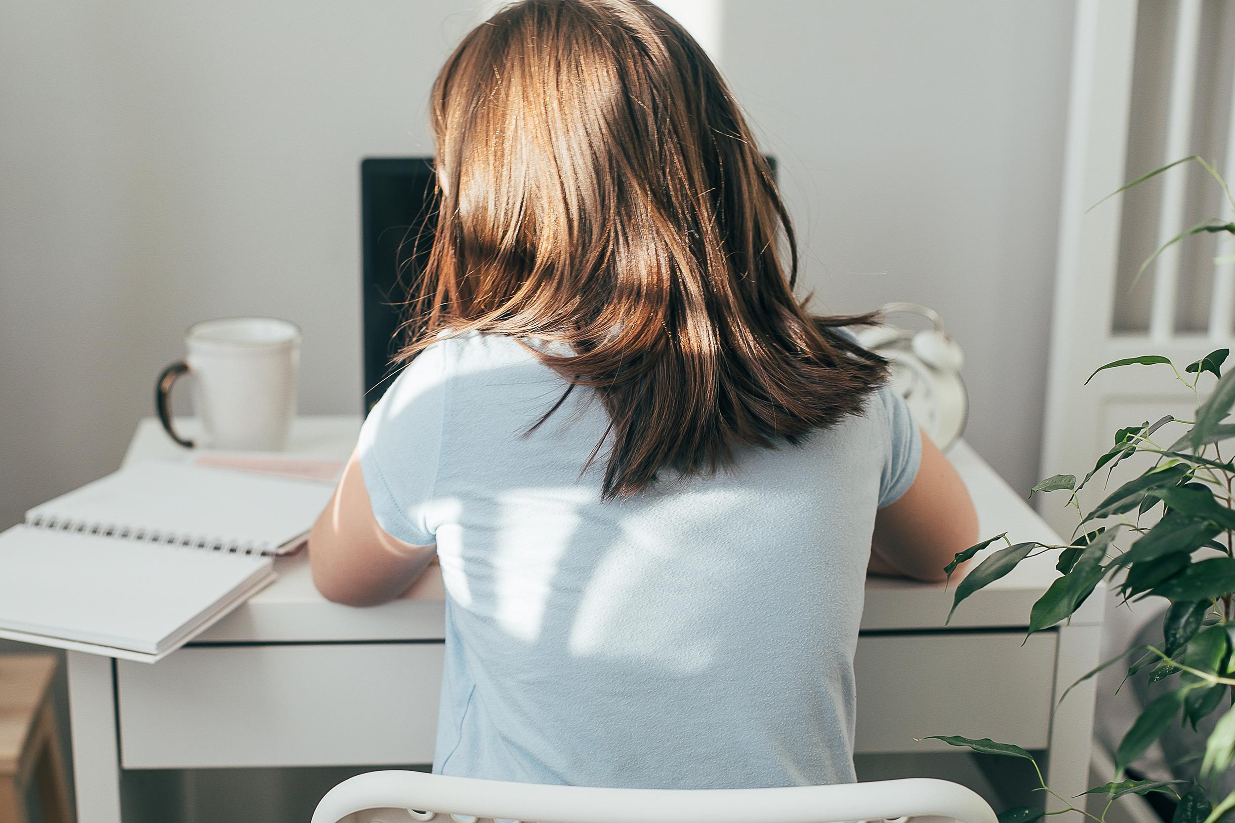 Student studying online at home with headphones