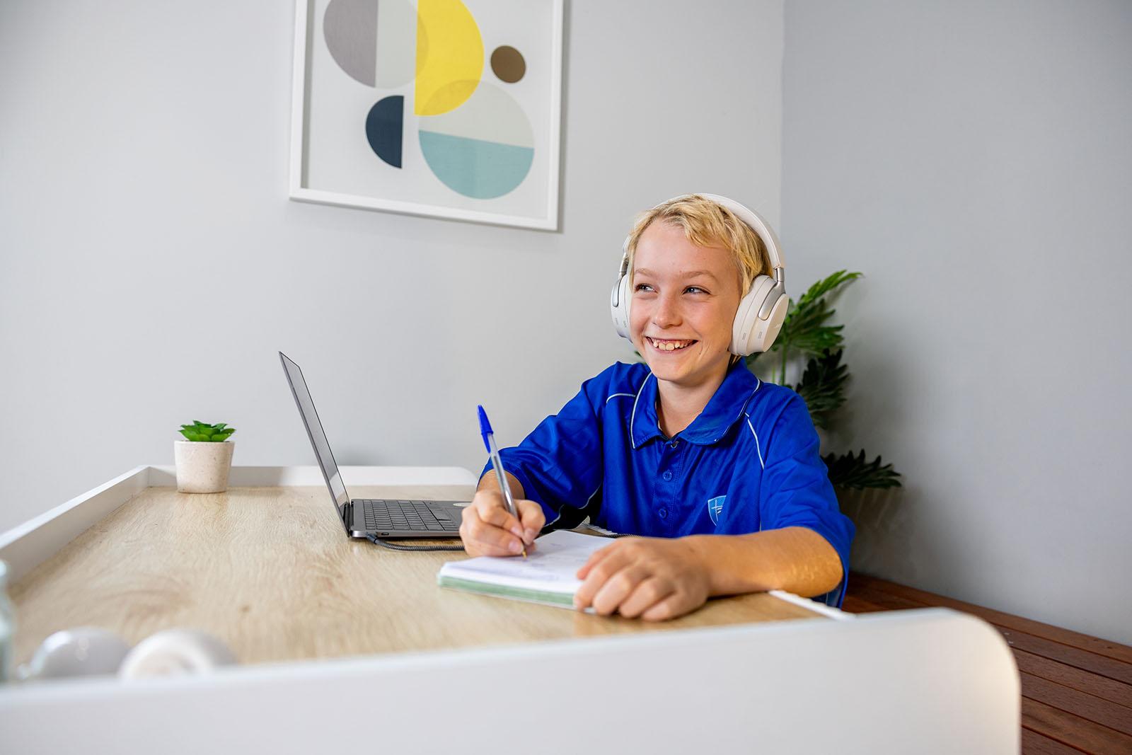 Student completing online learning on a laptop at home