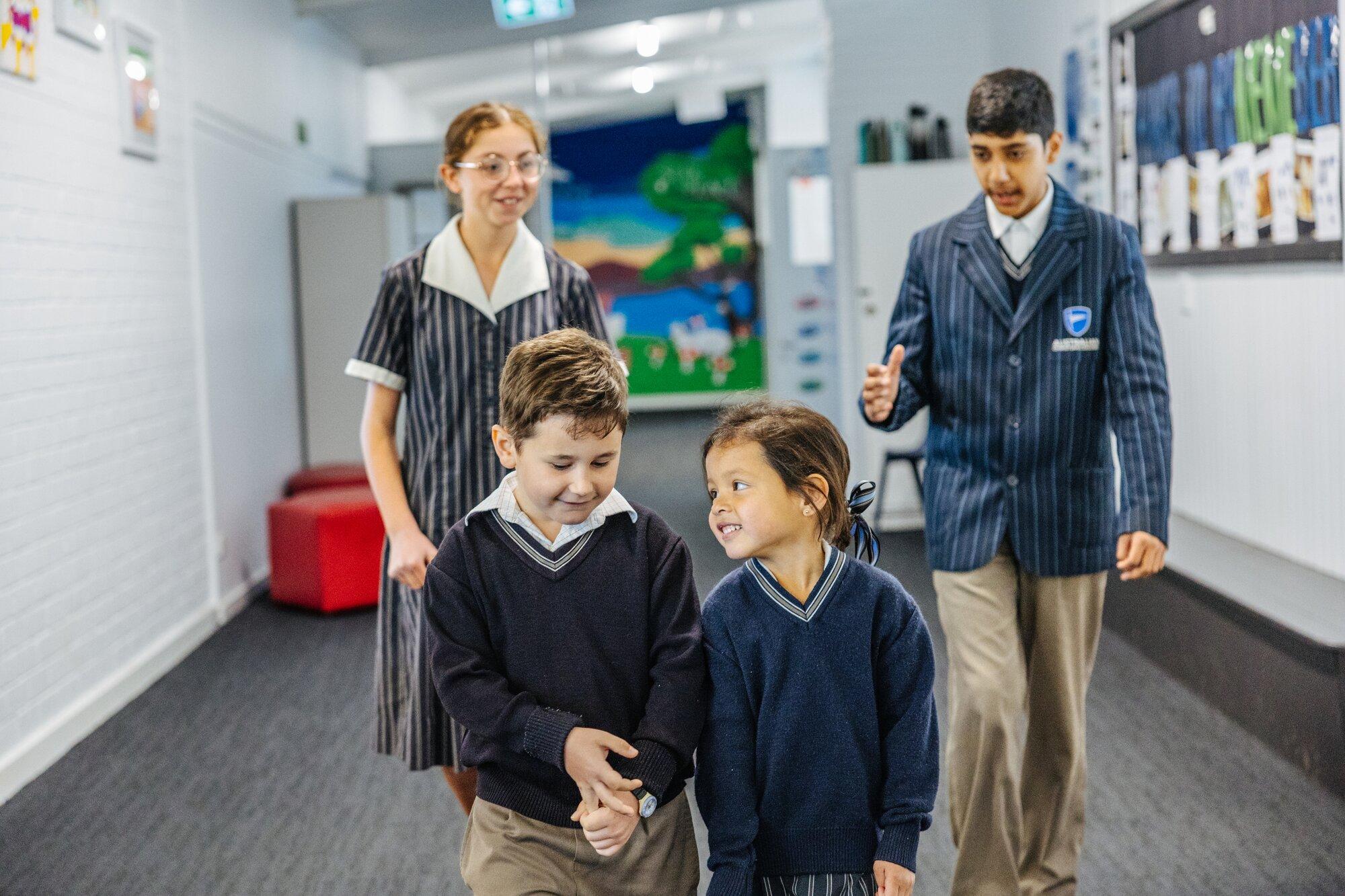 Students of all ages walking the campus hallway on a school tour