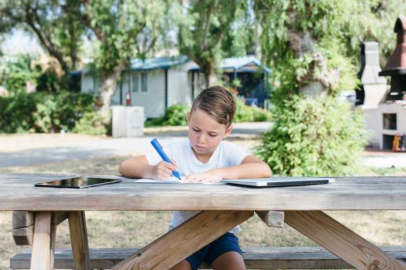 9 year old boy completing school work from backyard