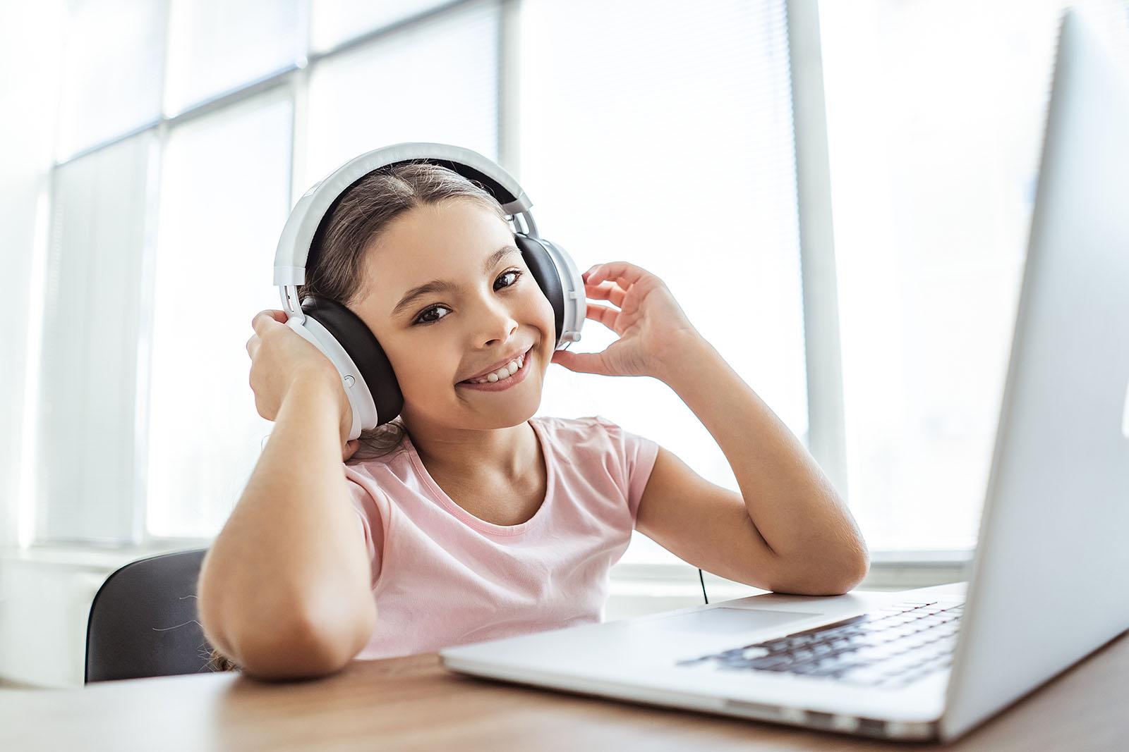 Primary student using headphones and laptop for online learning