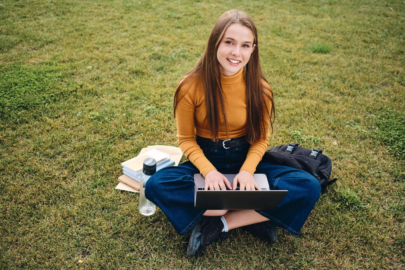 Student learning outdoors on a laptop