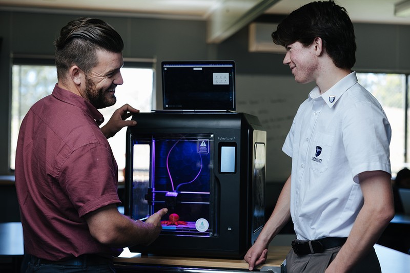 Male teacher showing high school studnet how to build desktop computer