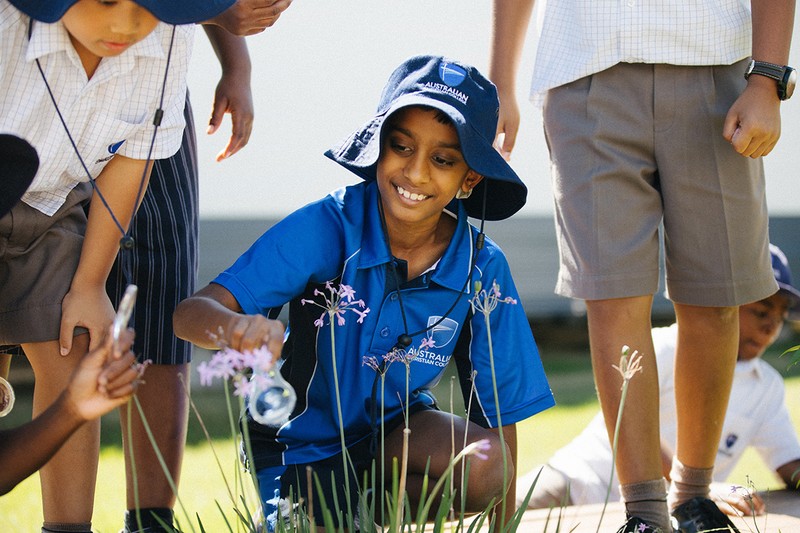 ACC Marsden Park student in sports uniform kneeling by flowers