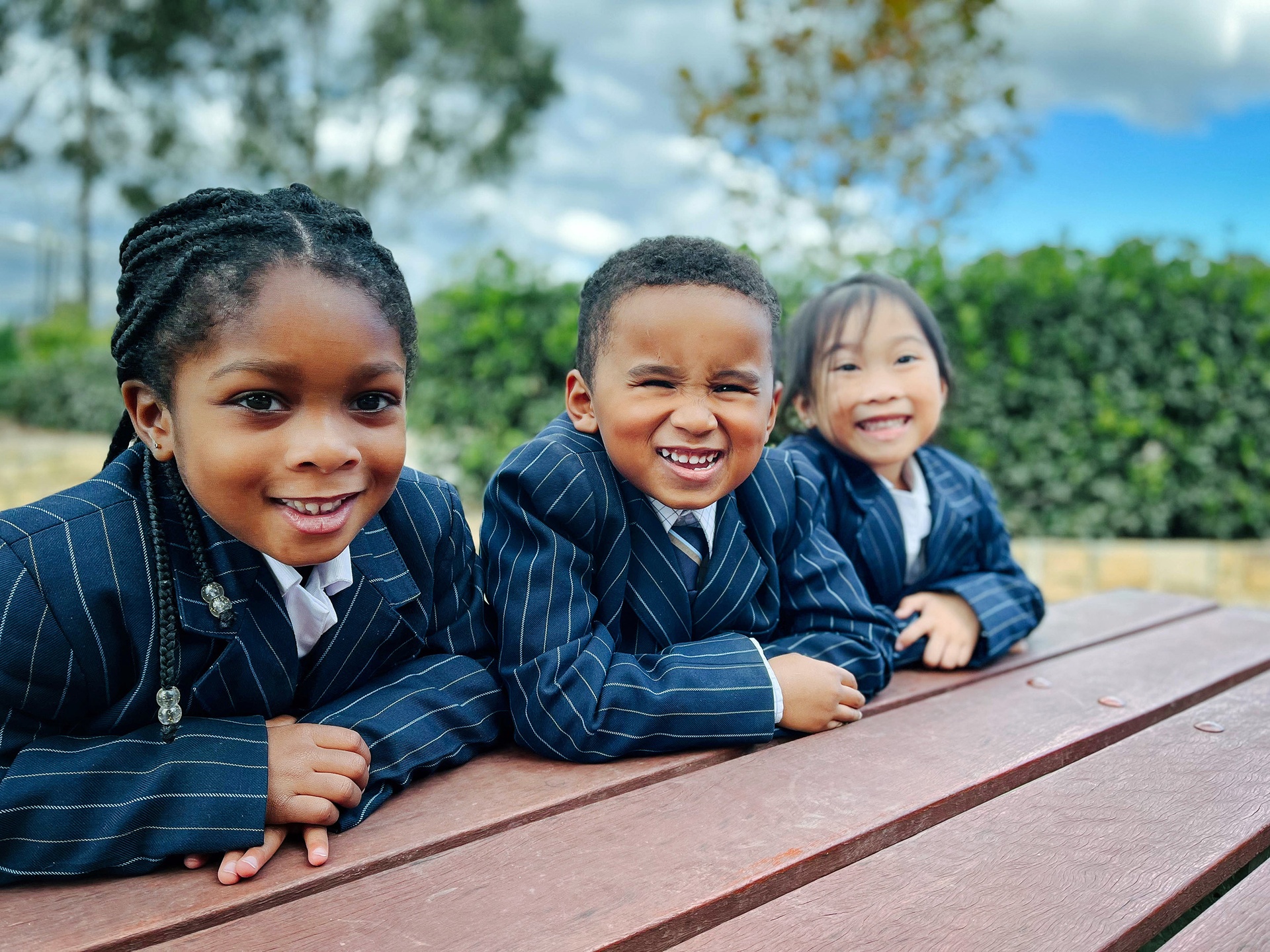Three Marsden Park Kindergarten students in blazers sitting at bench