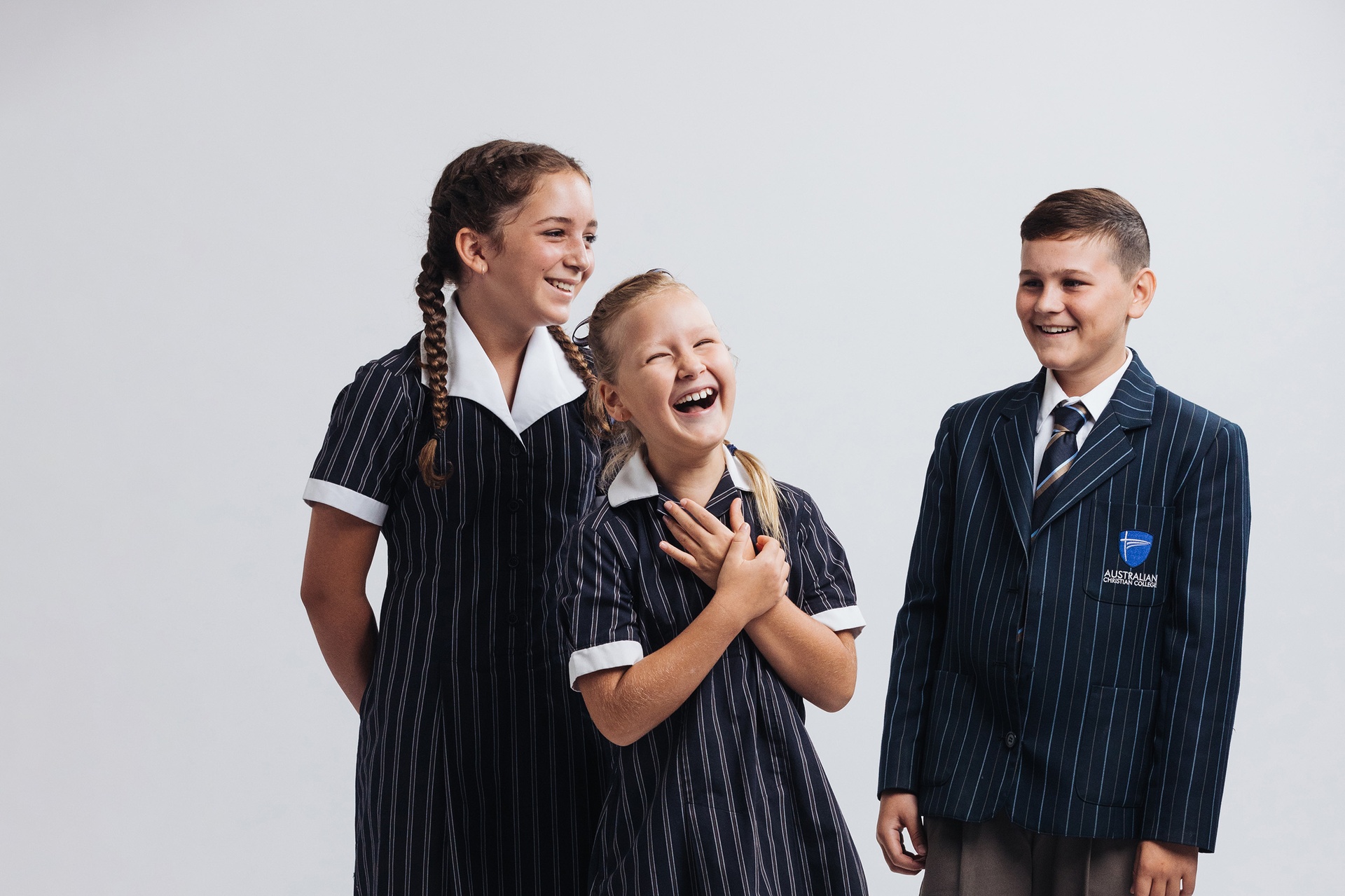 Three ACC Northwest Sydney students in uniform laughing together