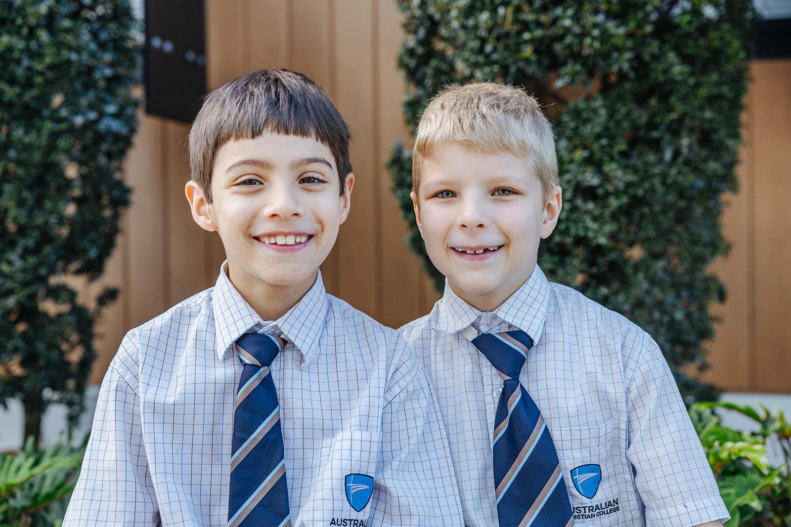 Two ACC Moreton primary boys in uniform smiling on campus