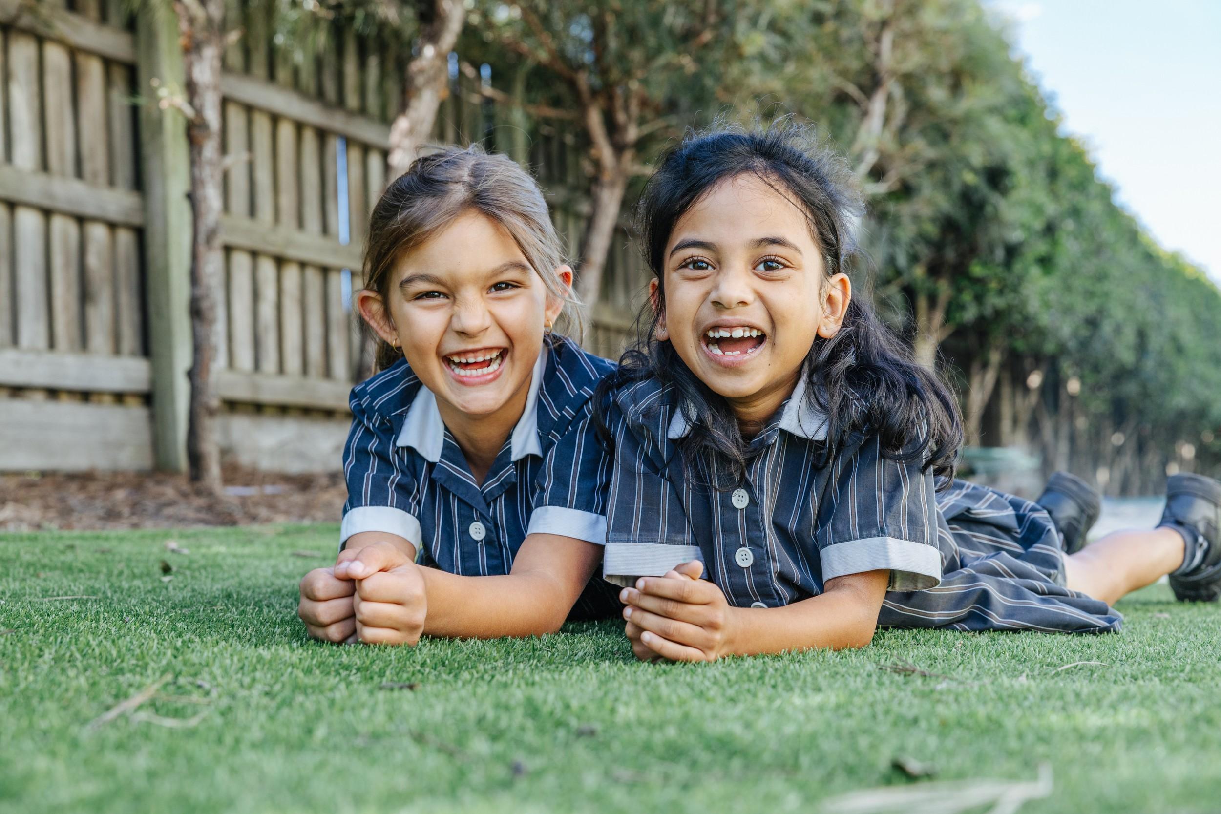 Two ACC Moreton primary students smiling on the school oval