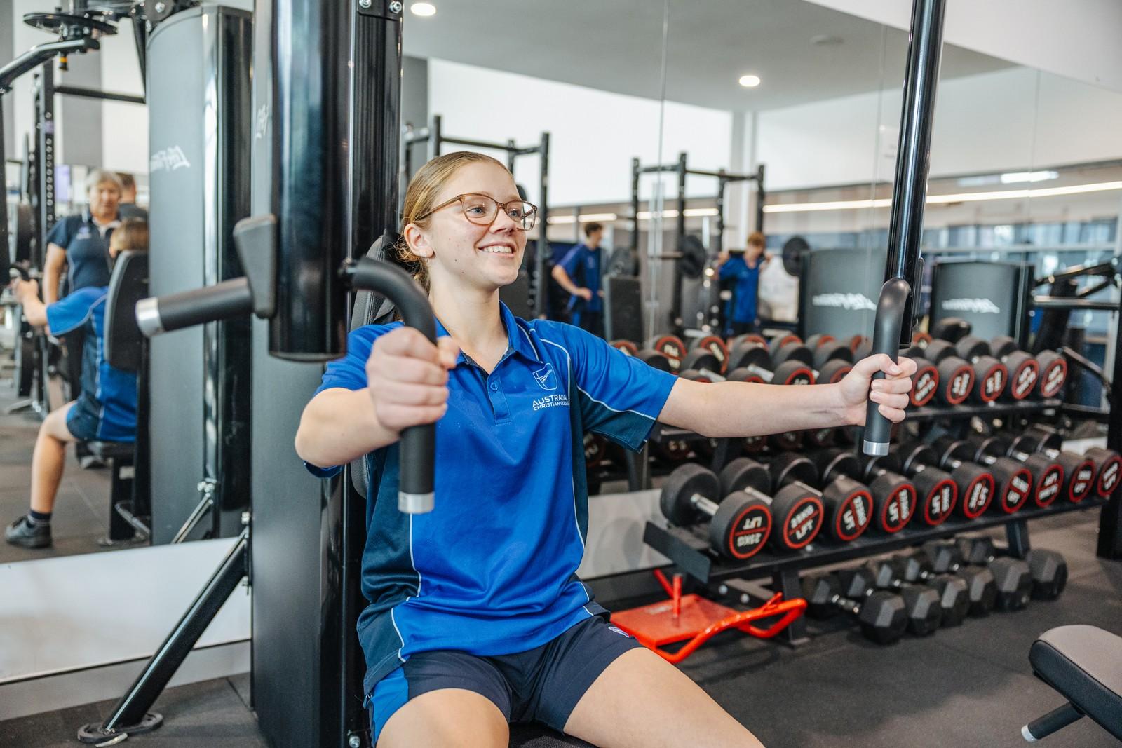 Secondary student training on a chest press machine in the ACC Moreton gym