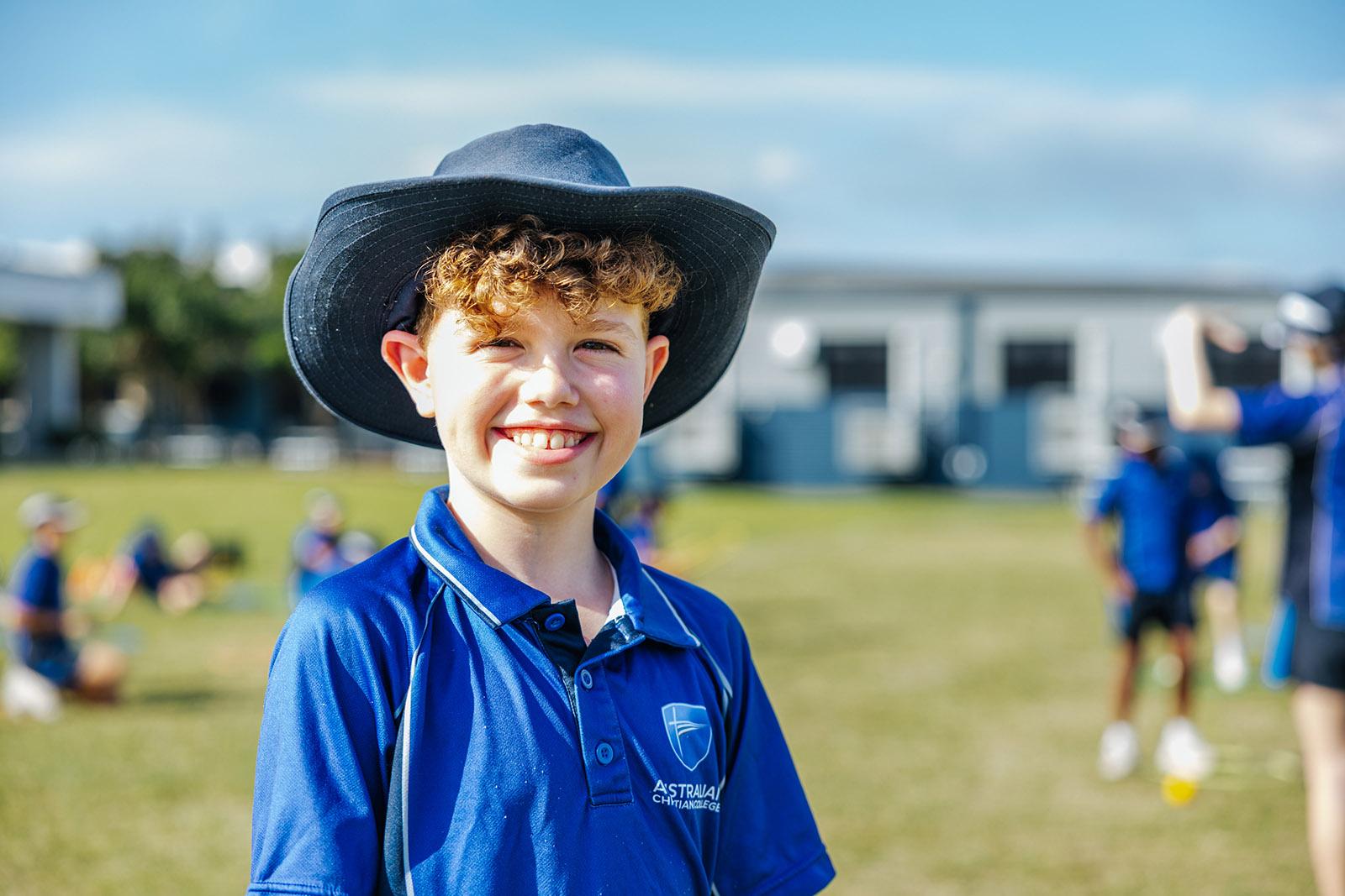 Primary student smiling on the school oval at ACC Moreton.