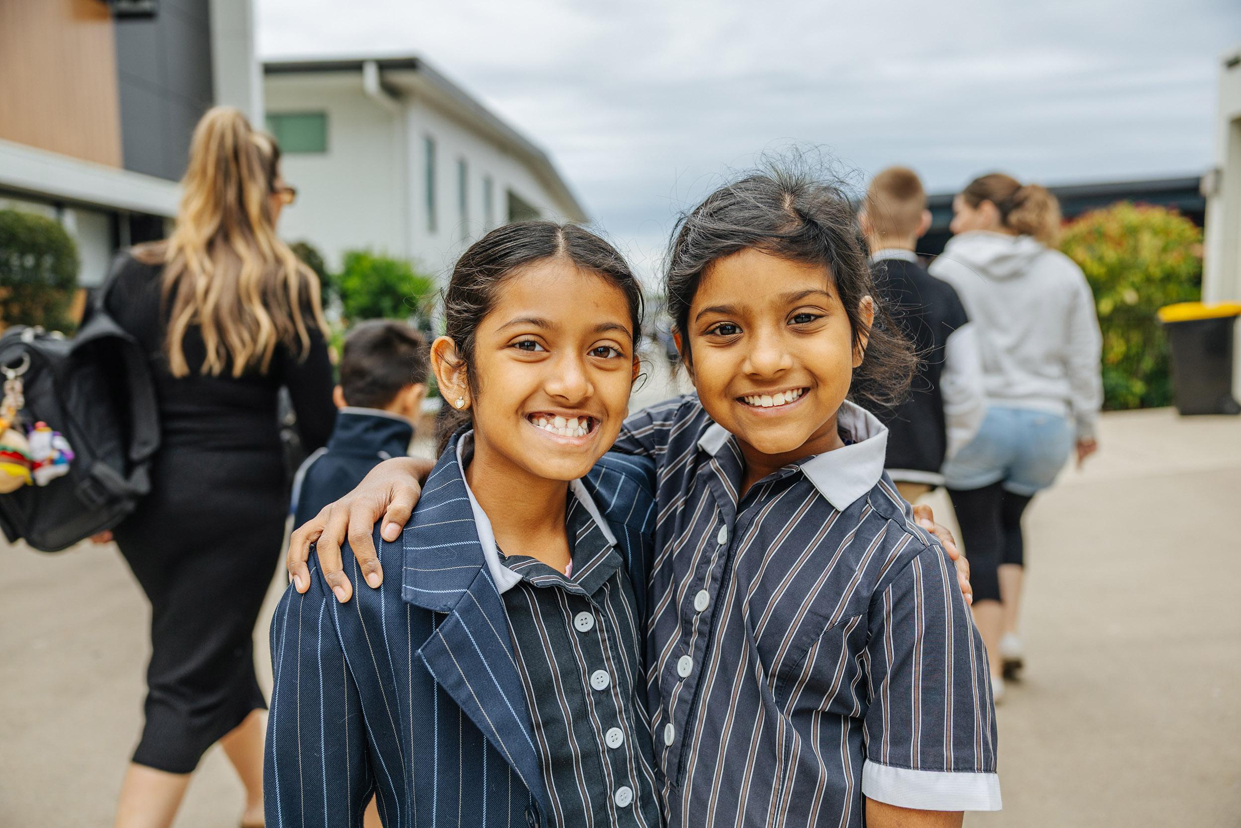 Two students smiling together on campus at ACC Moreton.